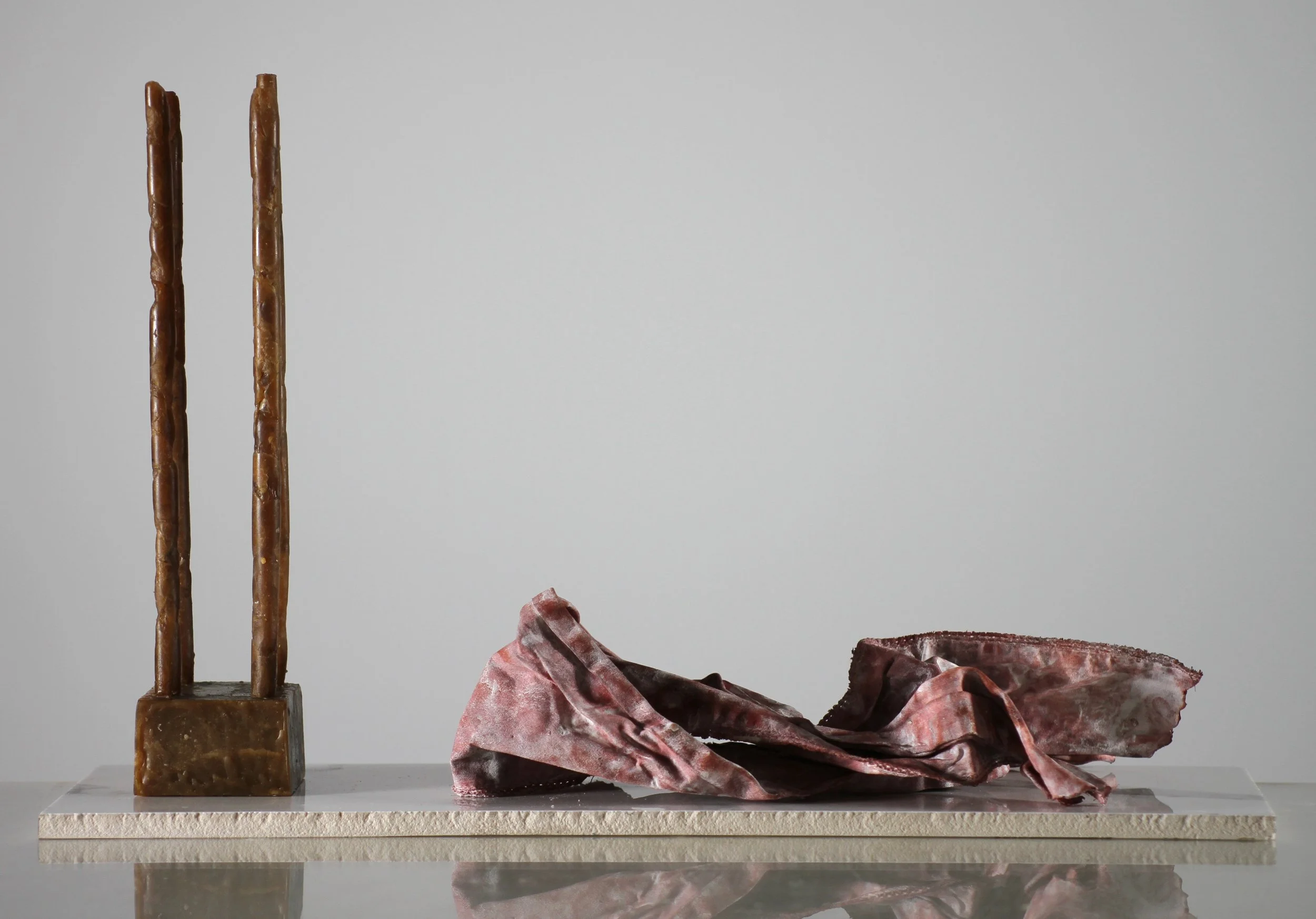 Object, Rag (2023), microcrystalline wax, fabric, plaster, stain, ceramic base, 12 1/2 x 23 1/2 x 11 3/4 inches