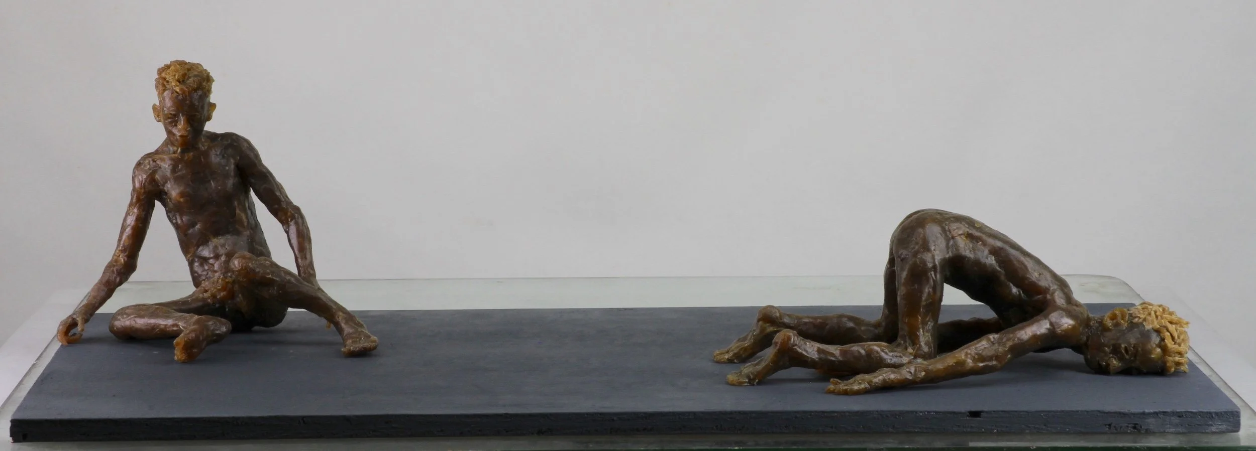 Two Figures (2021-2022), microcrystalline wax, painted wood base, 6 7/8 x 24 1/4 x 12 inches