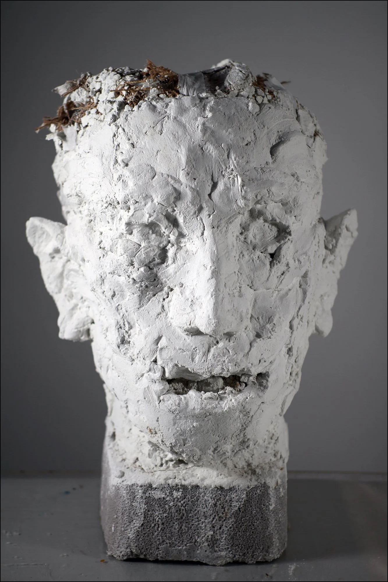 Large Head (2026), Winterstone, burlap, masking tape, cement base, 16 ¼ x 12 x 12 ¾ inches 