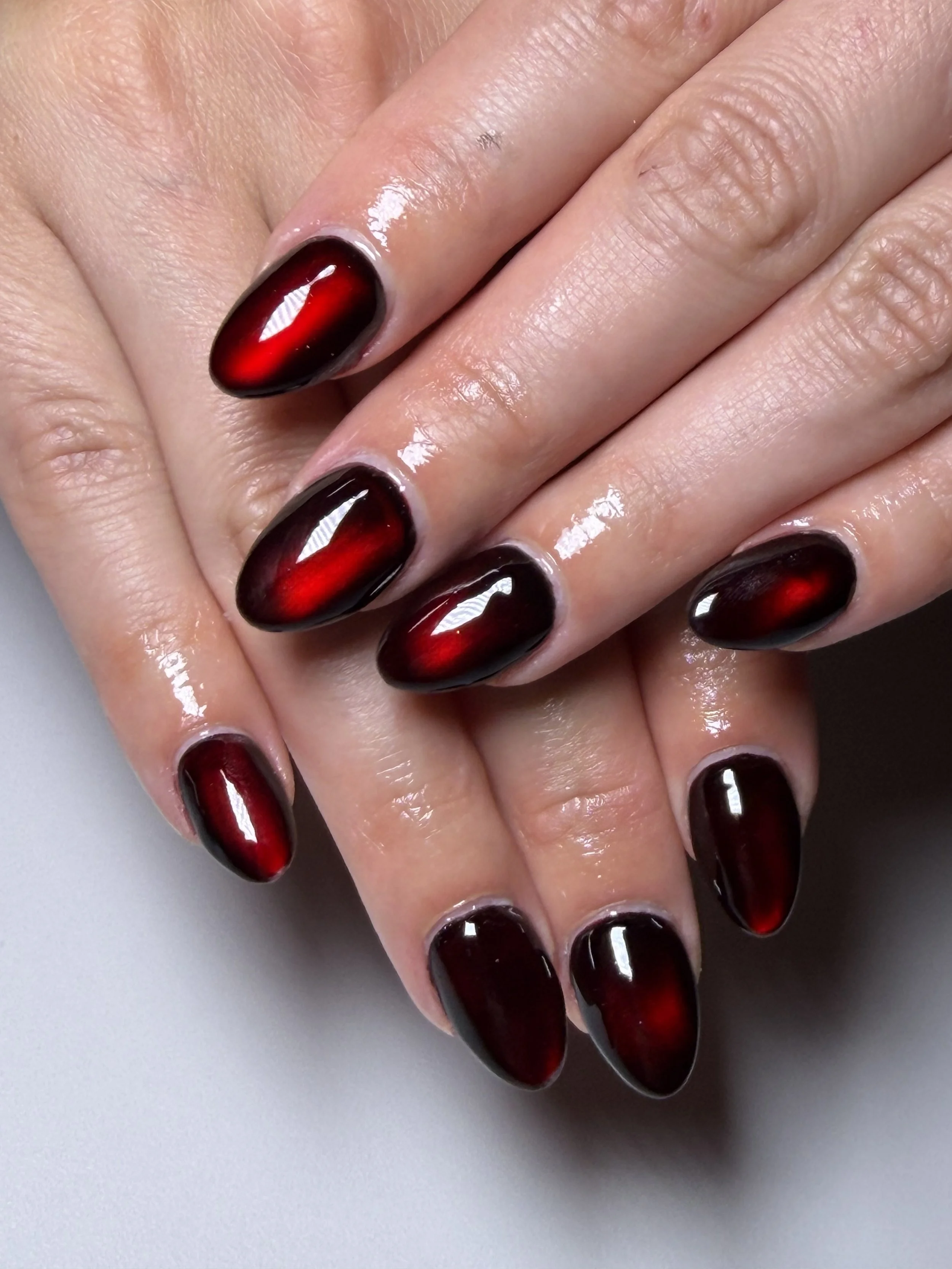 Vampire’s Kiss blood‑red cat eye press‑on nails, handmade and reusable, featuring a dramatic glossy finish.