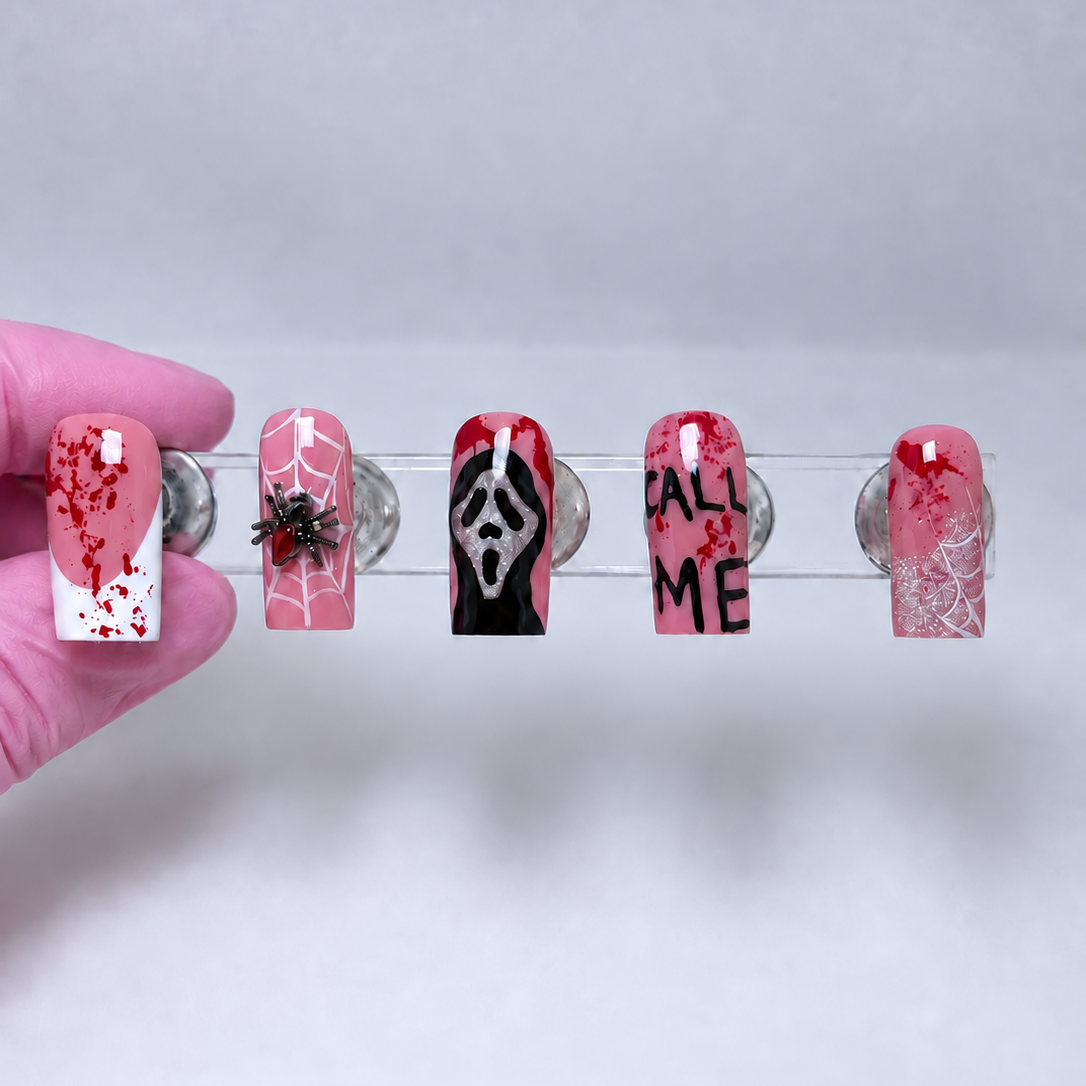 Scream Queen Halloween horror press-on nails displayed with Ghostface-inspired nail art, blood splatter designs, and a 3D spider charm