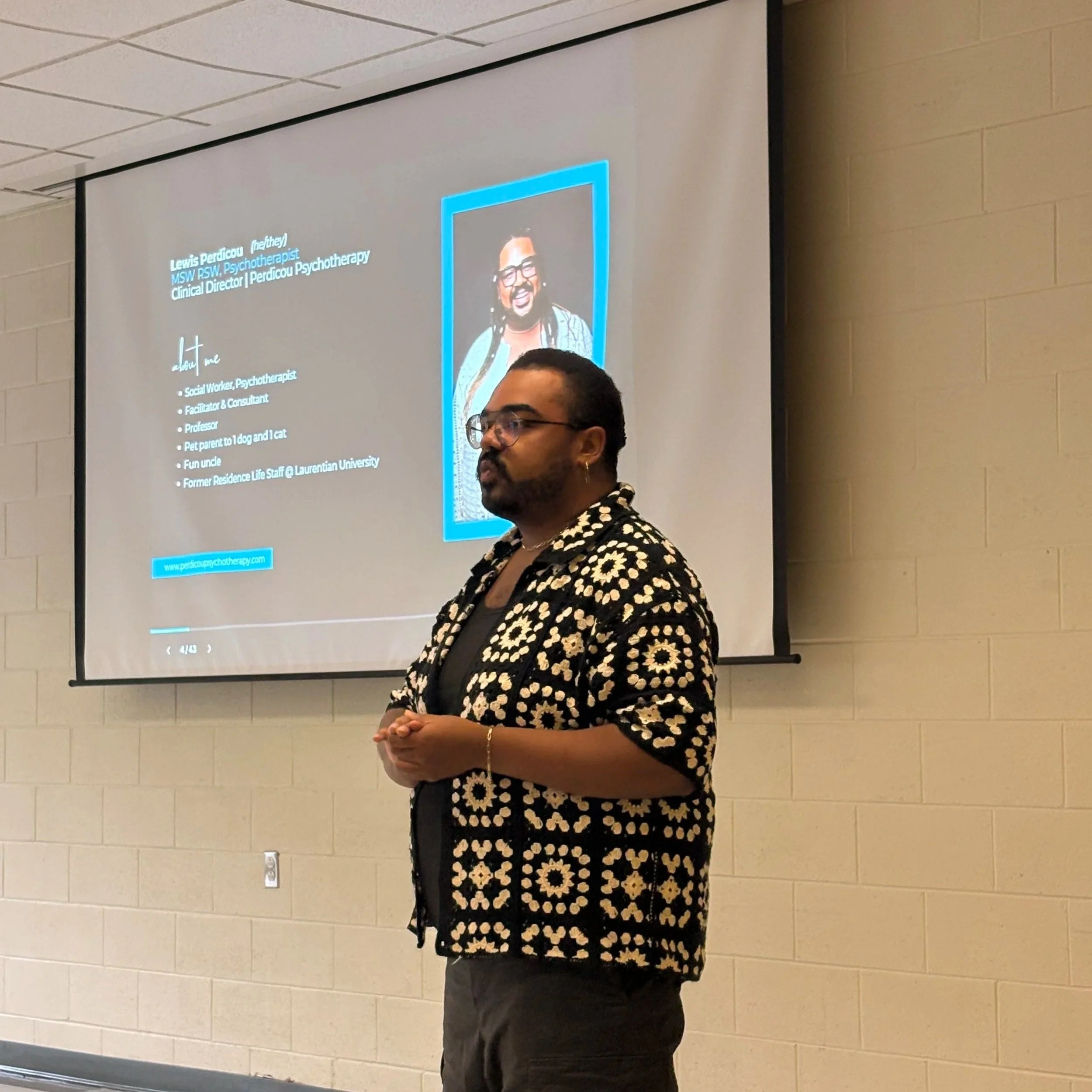 A man standing in front of a presentation screen with an image of himself on it and words