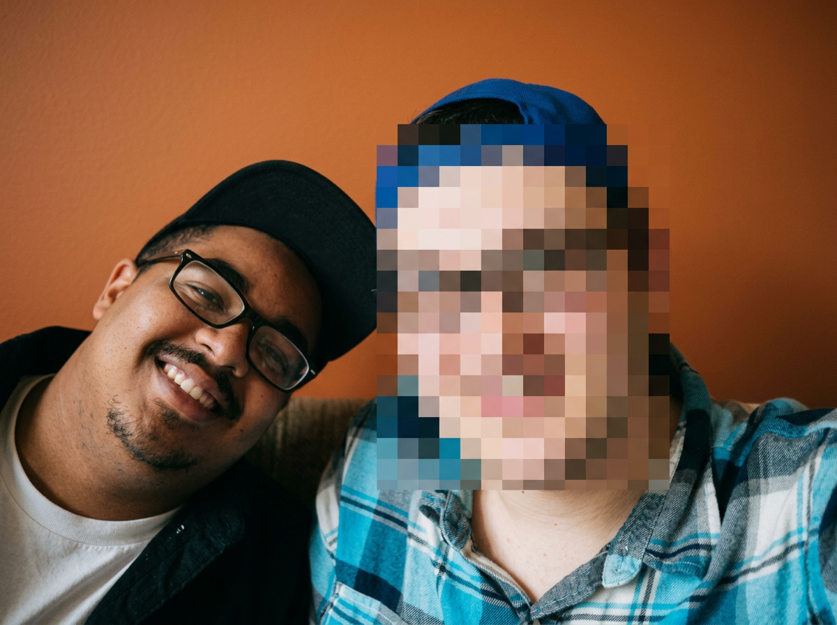 Two men wearing baseball hats smiling