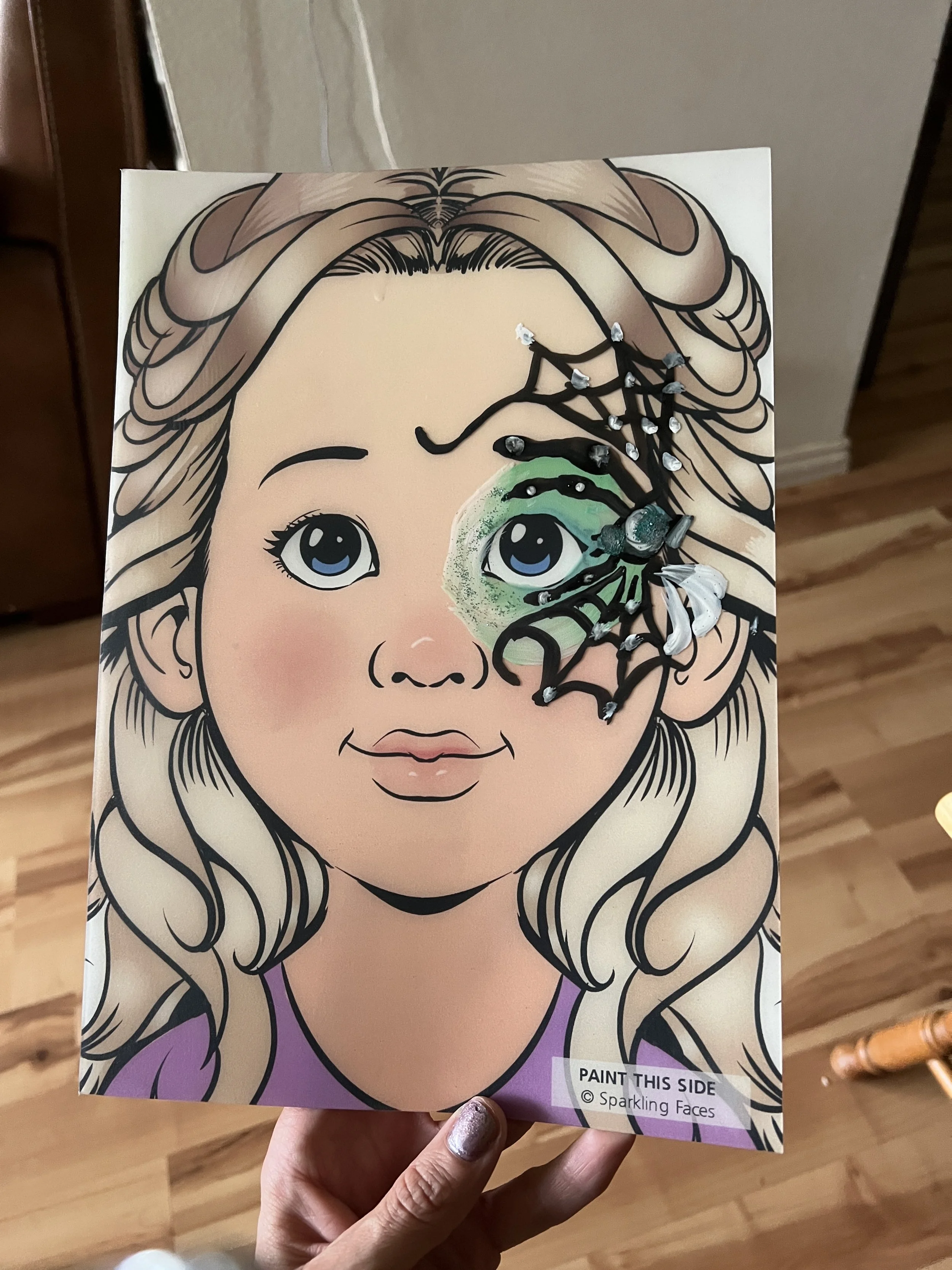 A coloring page of a young girl with long, wavy hair, and a butterfly-shaped design covering part of her face, decorated with rhinestones and glitter.