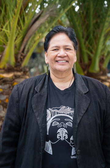 Headshot of Te Aroha, smiling, outdoors.