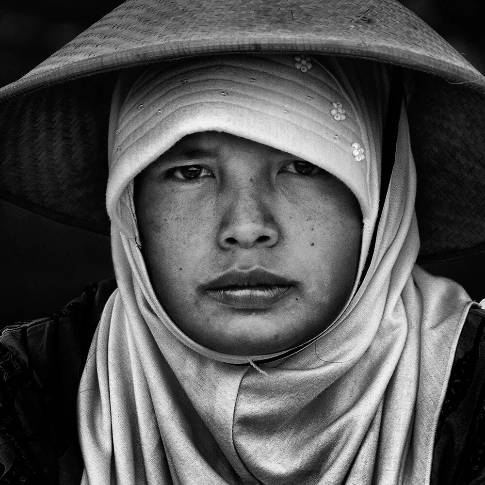 Kaliurang, Java, Indonésie — une jeune femme musulmane porte un chapeau conique sur son voile.