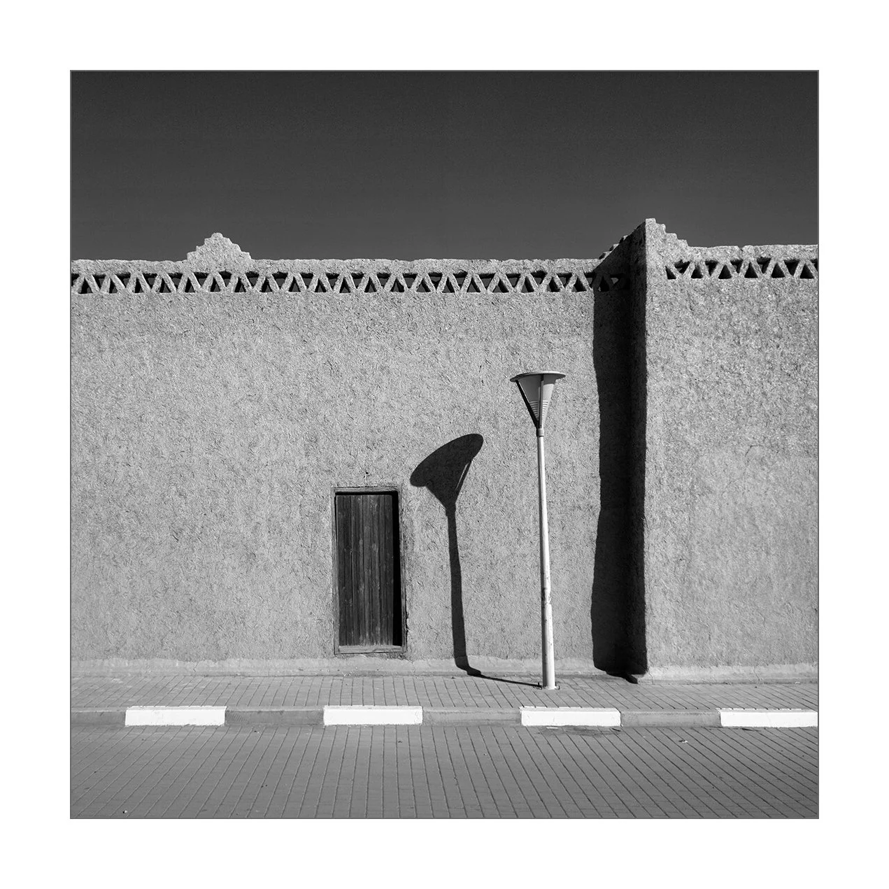 Hassilabied - l'ombre d'un lampadaire moderne sur la façade ancienne d'une maison en terre et paille