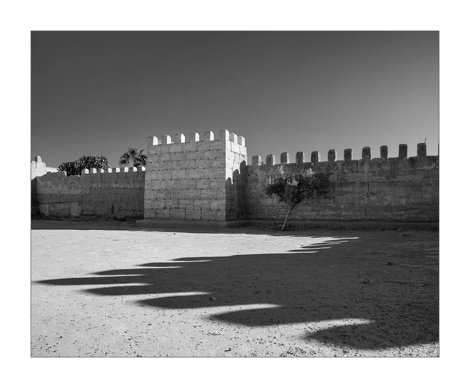 Taroudant, Maroc — l’ombre étirée des remparts se projette sur le sol au petit matin.