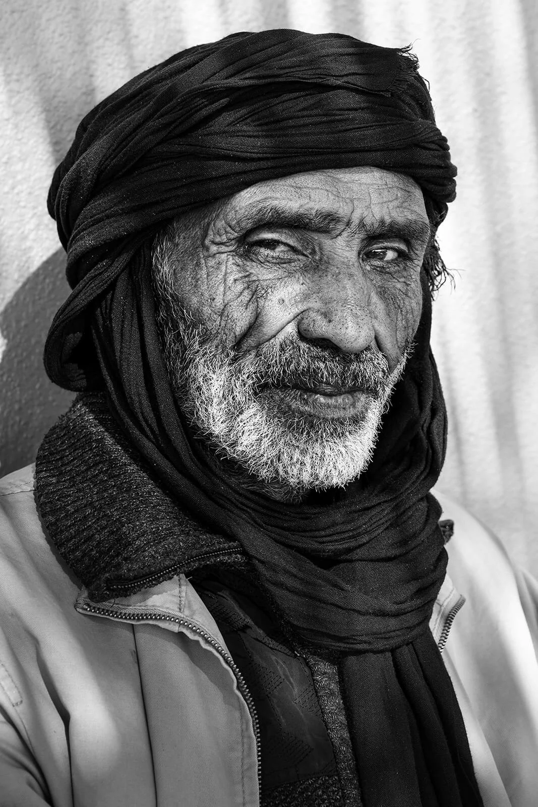 Aglou, Maroc — gros plan sur le visage d’un homme portant un chèche noir.