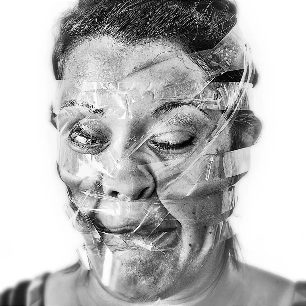 Visage féminin dont les traits sont tirés vers l'arrière par le ruban, créant un air de surprise forcée. Portrait d'art humoristique avec un traitement noir et blanc profond.