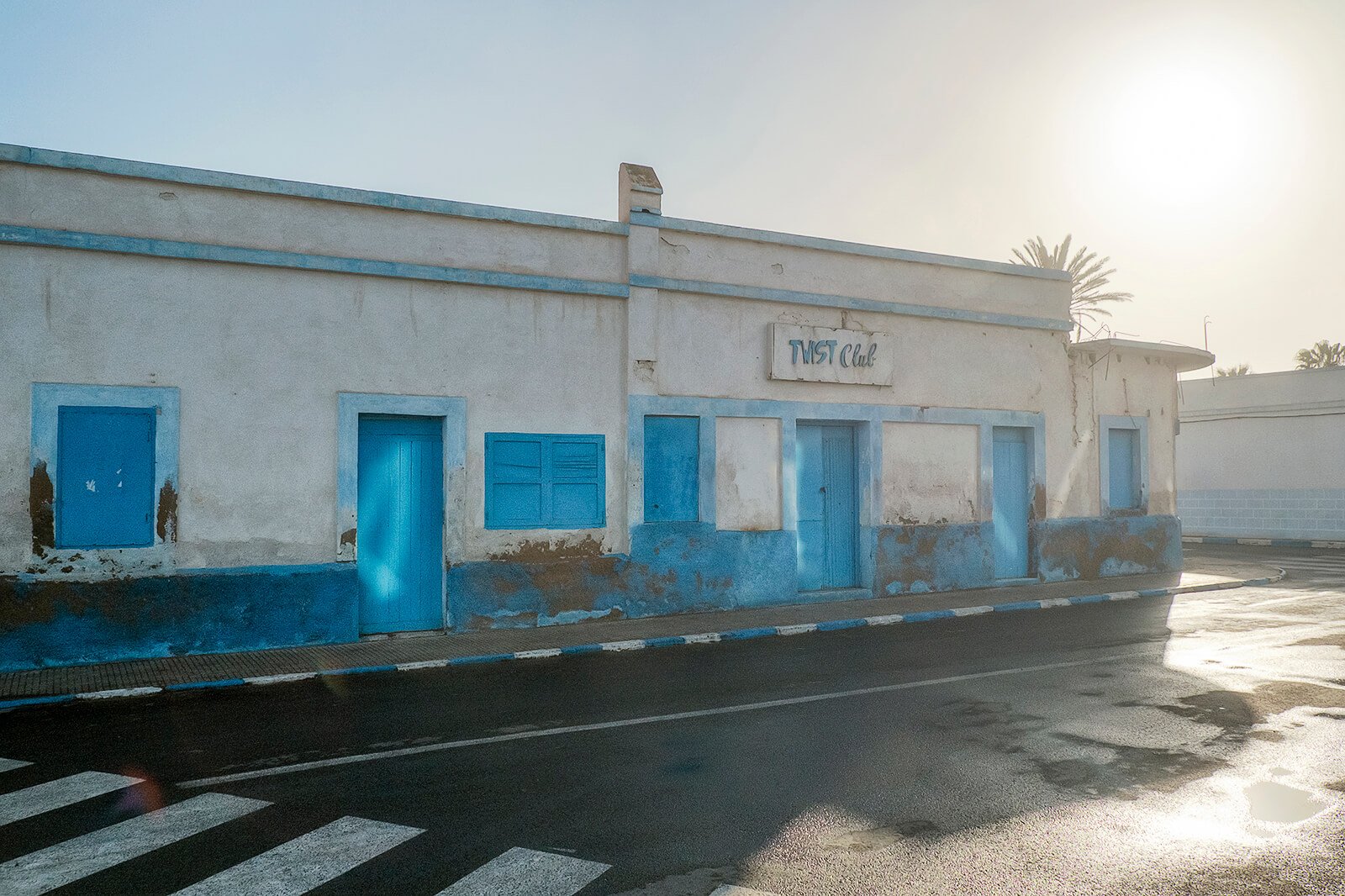 Sidi Ifni, Maroc — La façade bleu et blanc défraichie d'un ancien club de bord de mer.