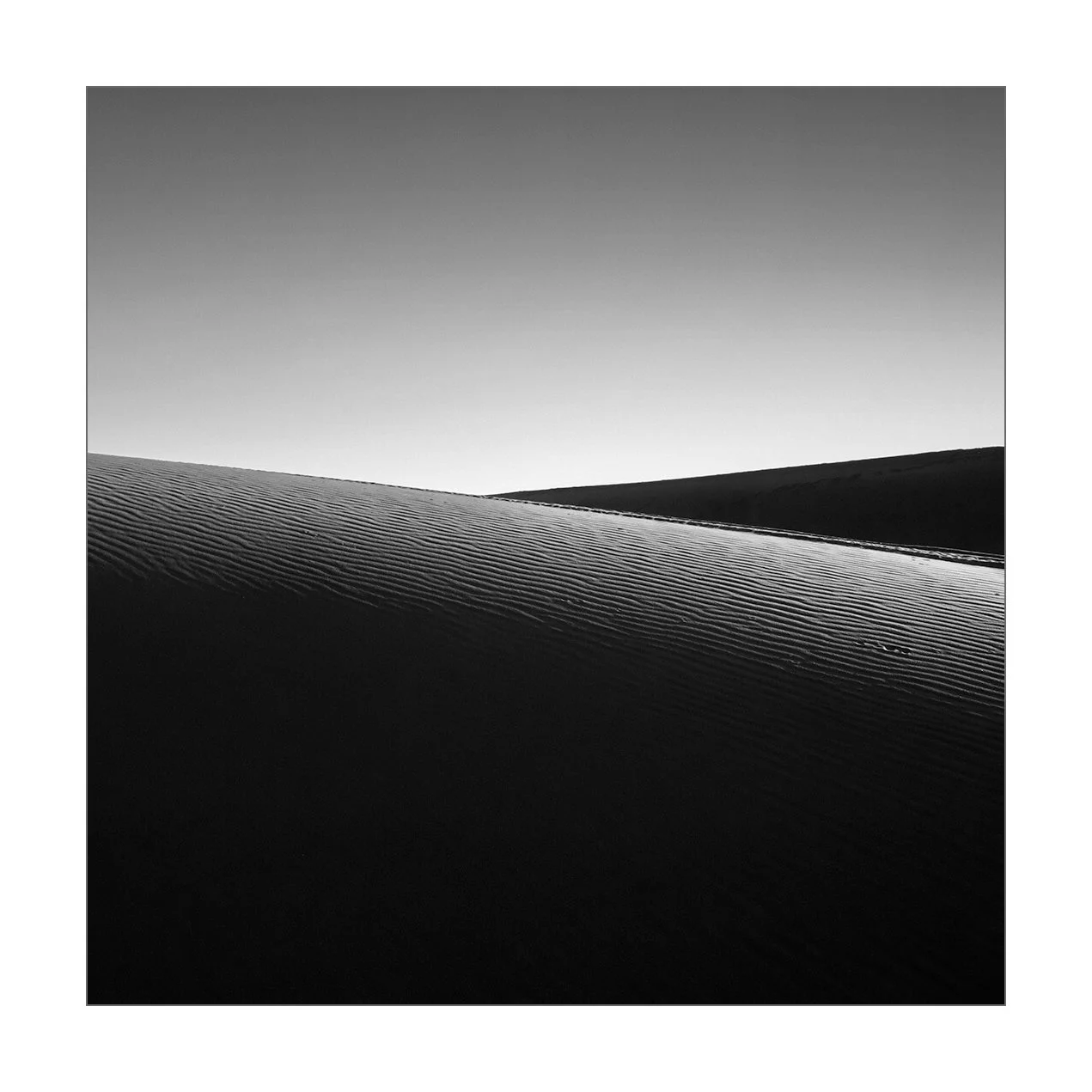 Merzouga, Maroc — minimalisme sur les rides du sable au coucher du soleil.