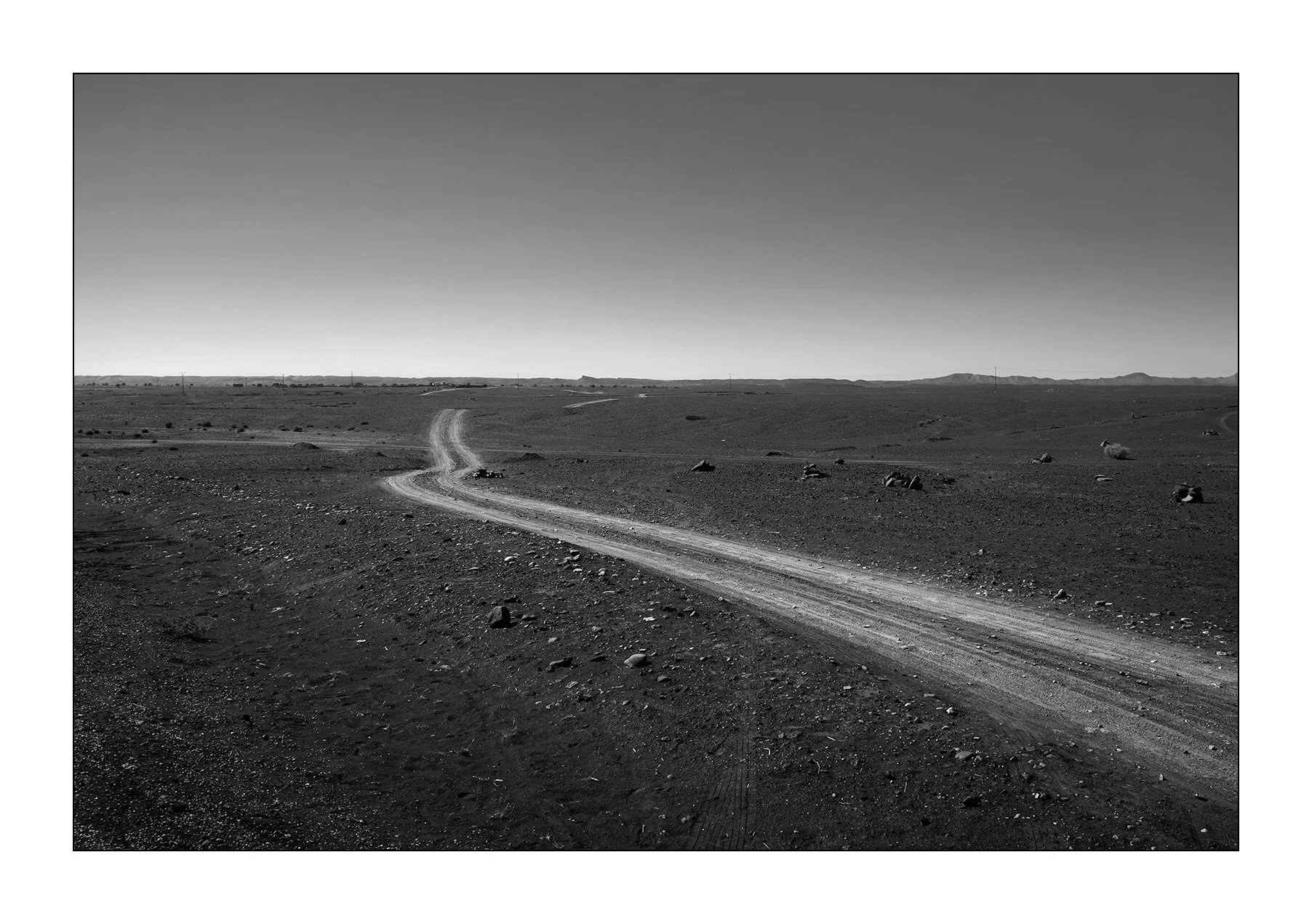 Hassilabied, Maroc — un chemin de terre serpente à travers le reg rocailleux.
