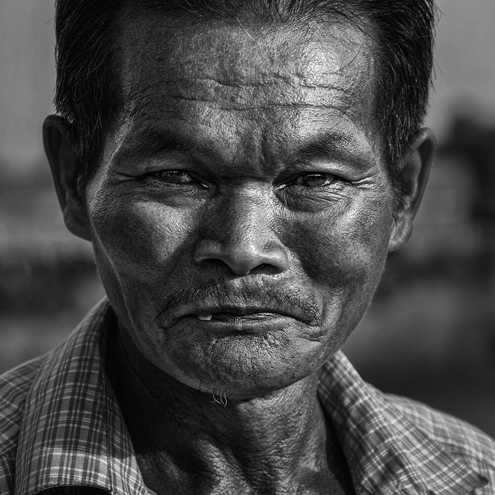 Ayutthaya, Thaïlande — portrait serré d’un Thaïlandais à la peau sombre marquée par le temps.