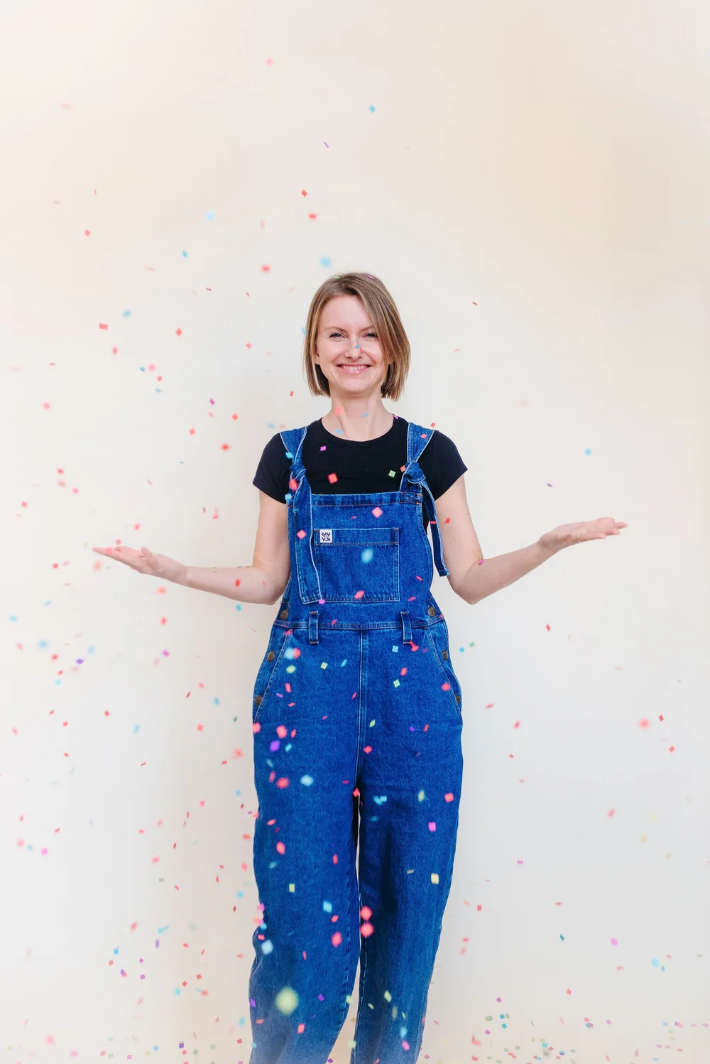 Malka in een spijkertuinbroek tussen vallende confetti