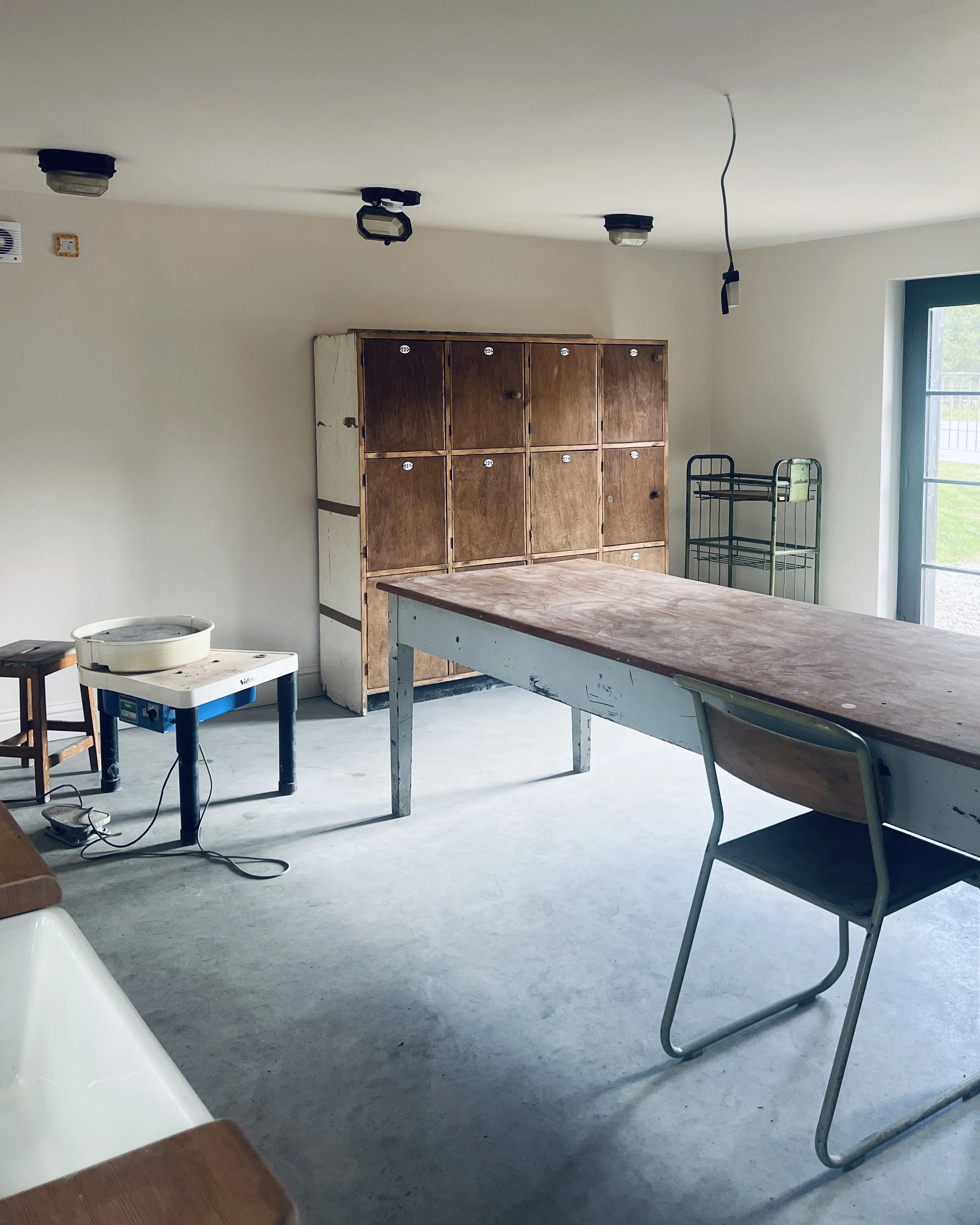 Pottery wheel and large workbench inside Kim Plimley's home ceramics studio in Carrbridge