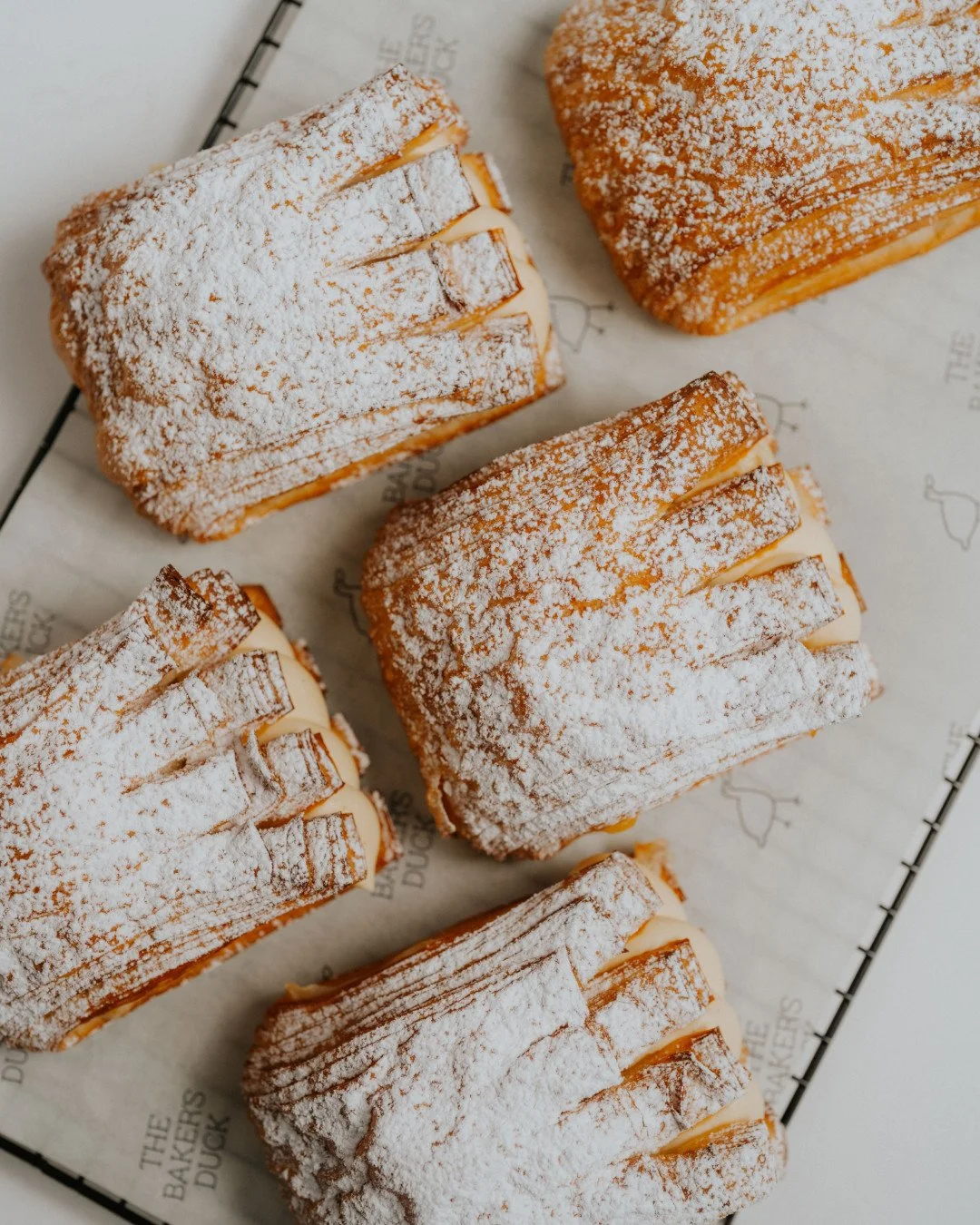 The Summer Stone FruitBear Claw⁠
⁠
Layers baked golden, filled with silky custard and roasted seasonal stone fruit, topped with peach mousse and a light dusting of icing sugar. Sweet, summery and just messy enough to require two hands.⁠
⁠
Duck in sto