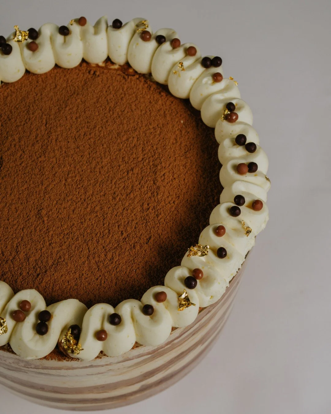 This Easter, leave dessert to us. 🤍⁠
⁠
Our Easter Tiramisu Trifle is coffee-soaked vanilla sponge, orange-spiced vanilla cream, cocoa and chocolate crisp pearls. Wave-piped, layered and finished with gold leaf. A centrepiece that makes everyone at t