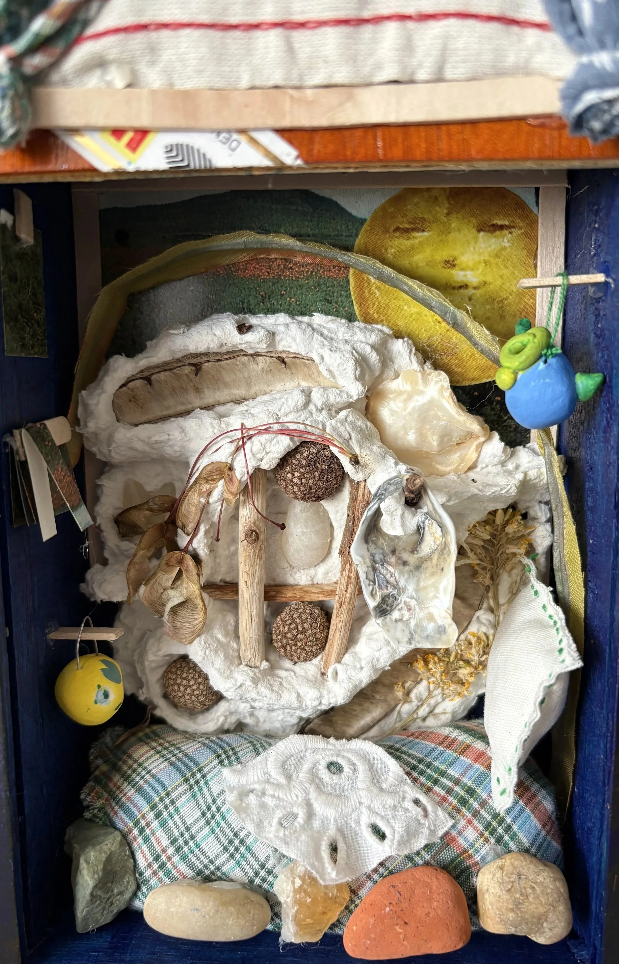 "Memorial Box", memorialization art making and honoring memory, multimedia piece: paper plaster, wood, sheel, Model Magic, paper, textiles, stone, and found objects