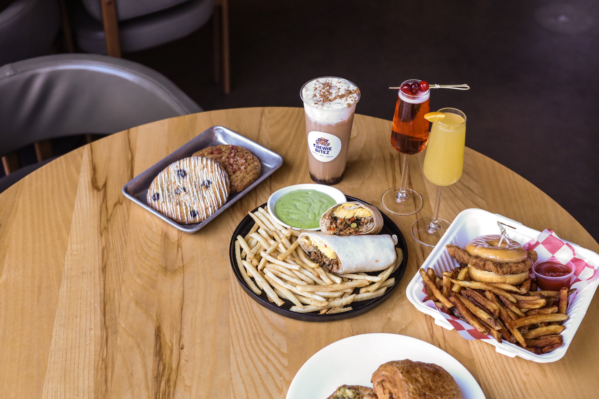 A spread of breakfast food items on a wooden table.