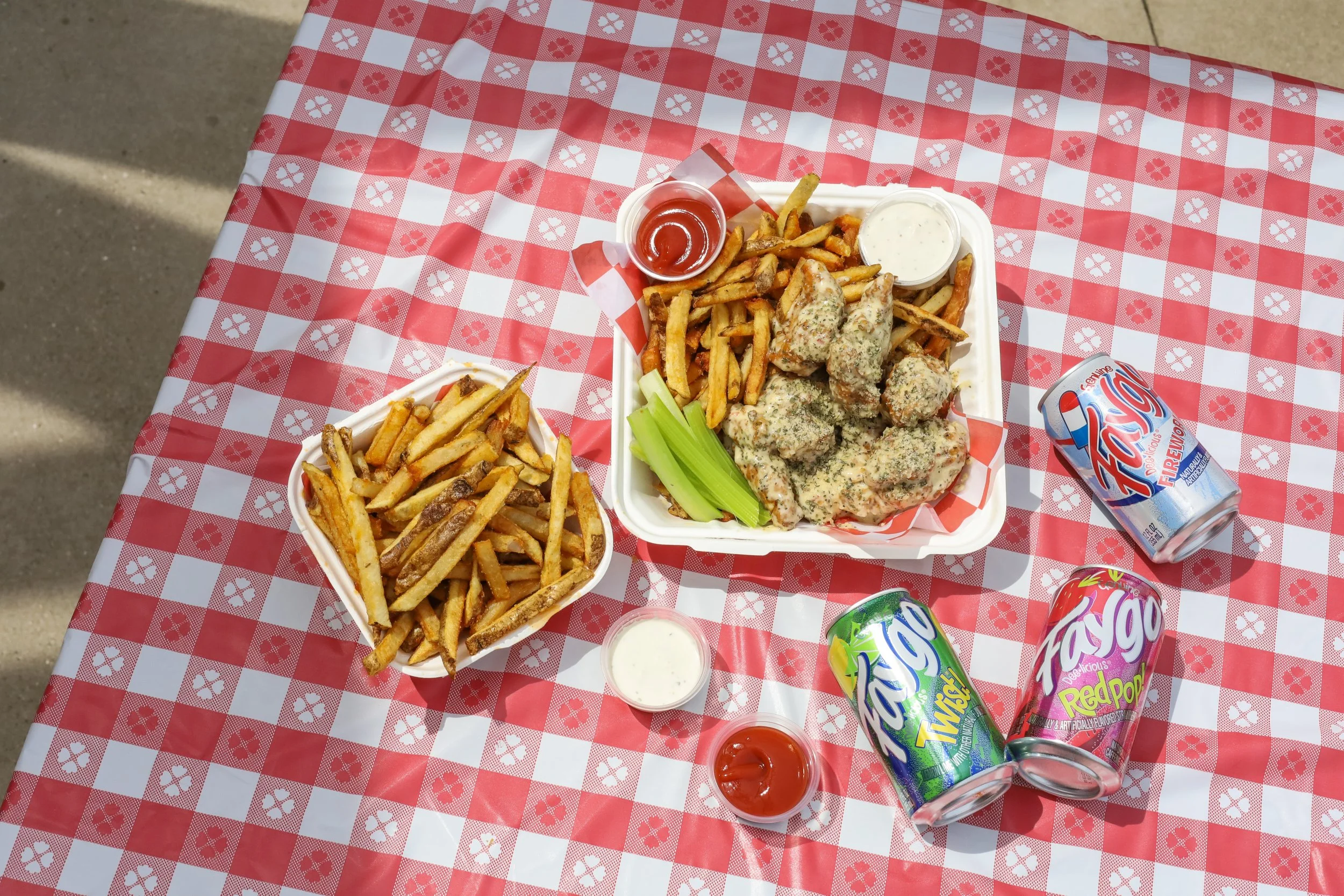Picnic setup with boneless chicken wings, fries, and soda