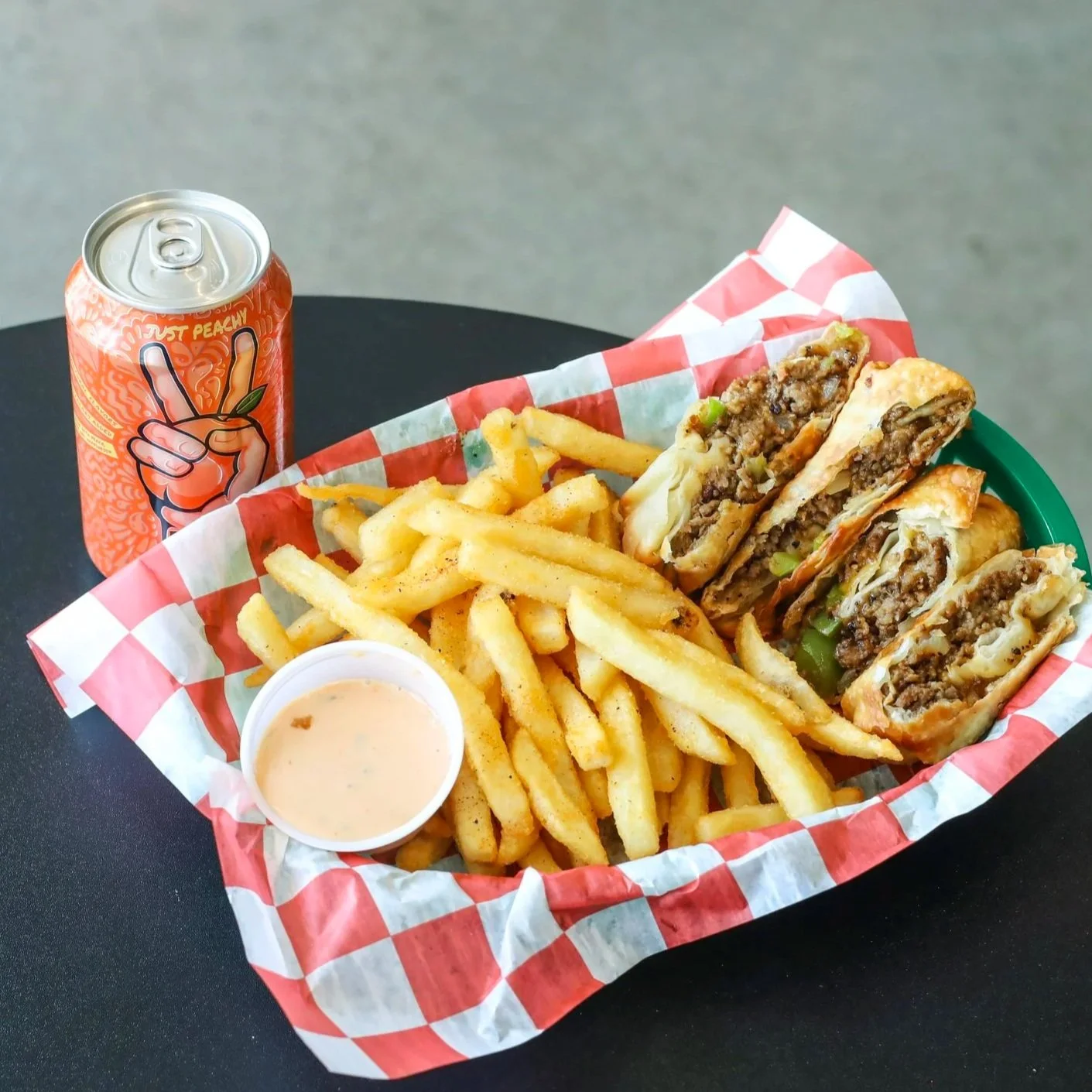 A basket of vegan egg rolls with fries and a canned drink.