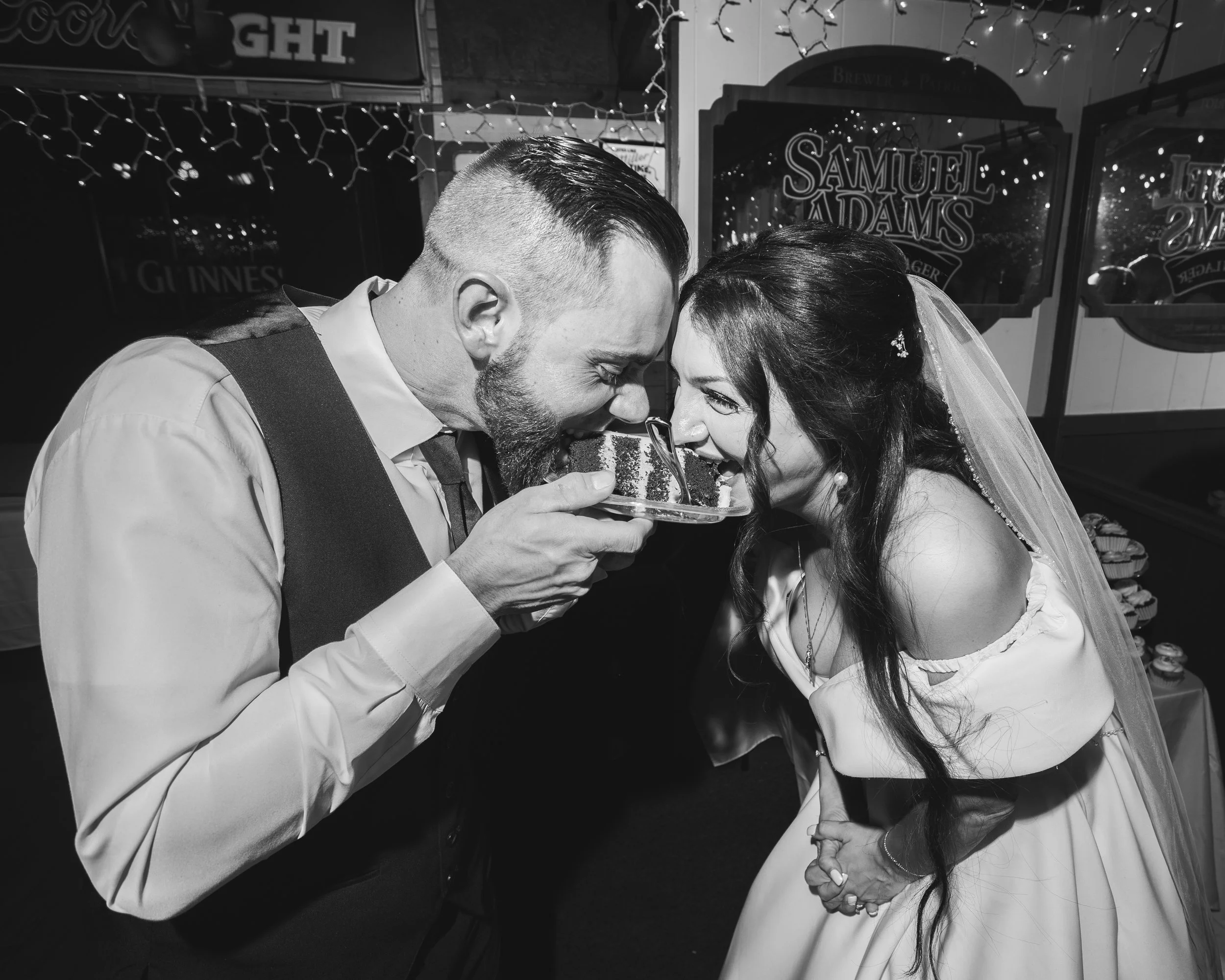 A bride and groom sharing a piece of cake at their wedding reception.