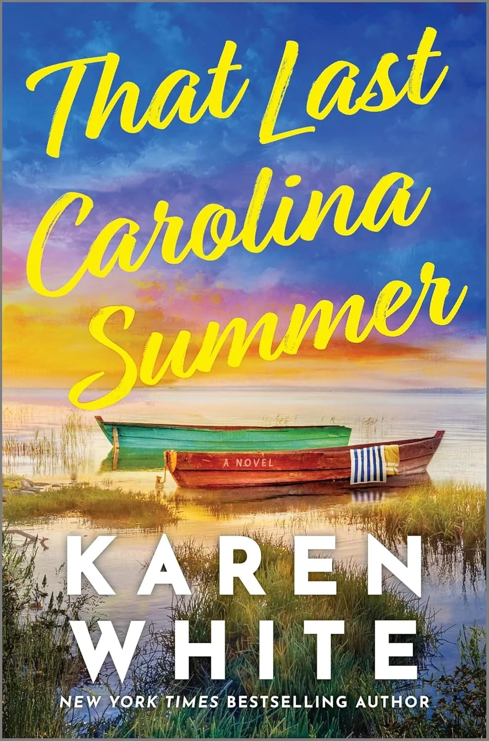 Book cover of "That Last Carolina Summer" by Karen White, featuring a sunset over a marsh with two boats, one green and one red, on calm water.