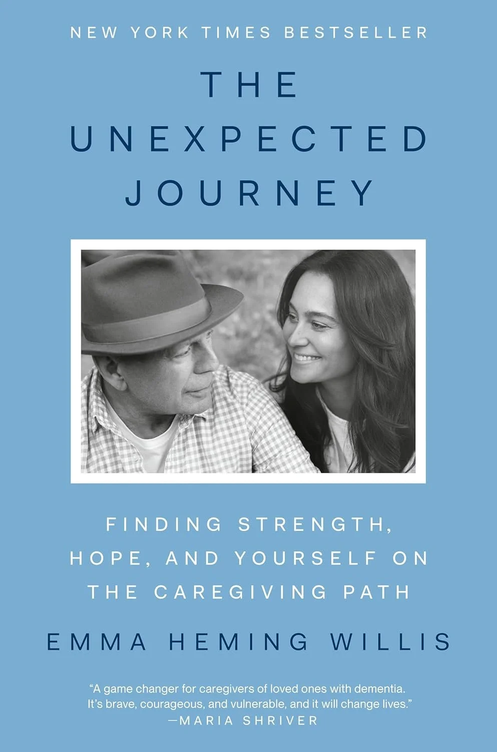 Cover of a book titled "The Unexpected Journey" with a blue background, a black-and-white photo of a man and woman smiling at each other, and text indicating it is a guide for caregivers.