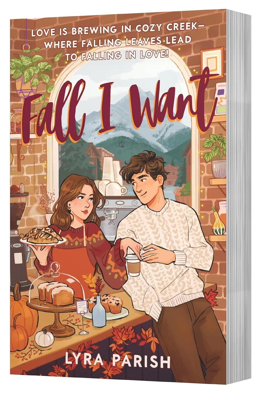 Book cover titled "Fall I Want" by Lyra Parish, depicting a cozy autumn scene with a couple in a warmly decorated kitchen with fall-themed items like pumpkins and baked goods, and a mountain landscape visible through a window.