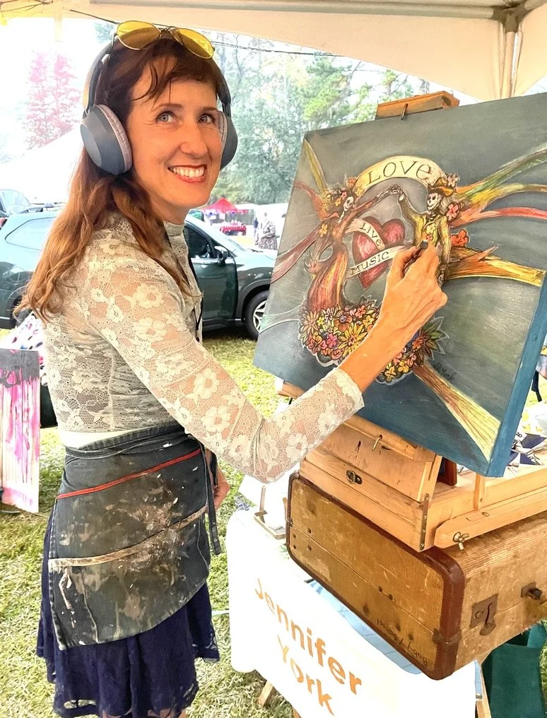 Jenna painting LIVE at Edisto Blackwater Boogie, 2025.  Many of Jenna's small works were cut and drawn live stageside, onsite in galleries, and out and about in the world.