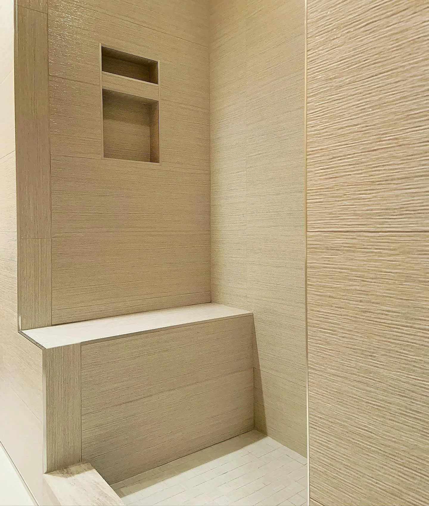 A minimalist beige and wood textured interior with beige shelves and panels.