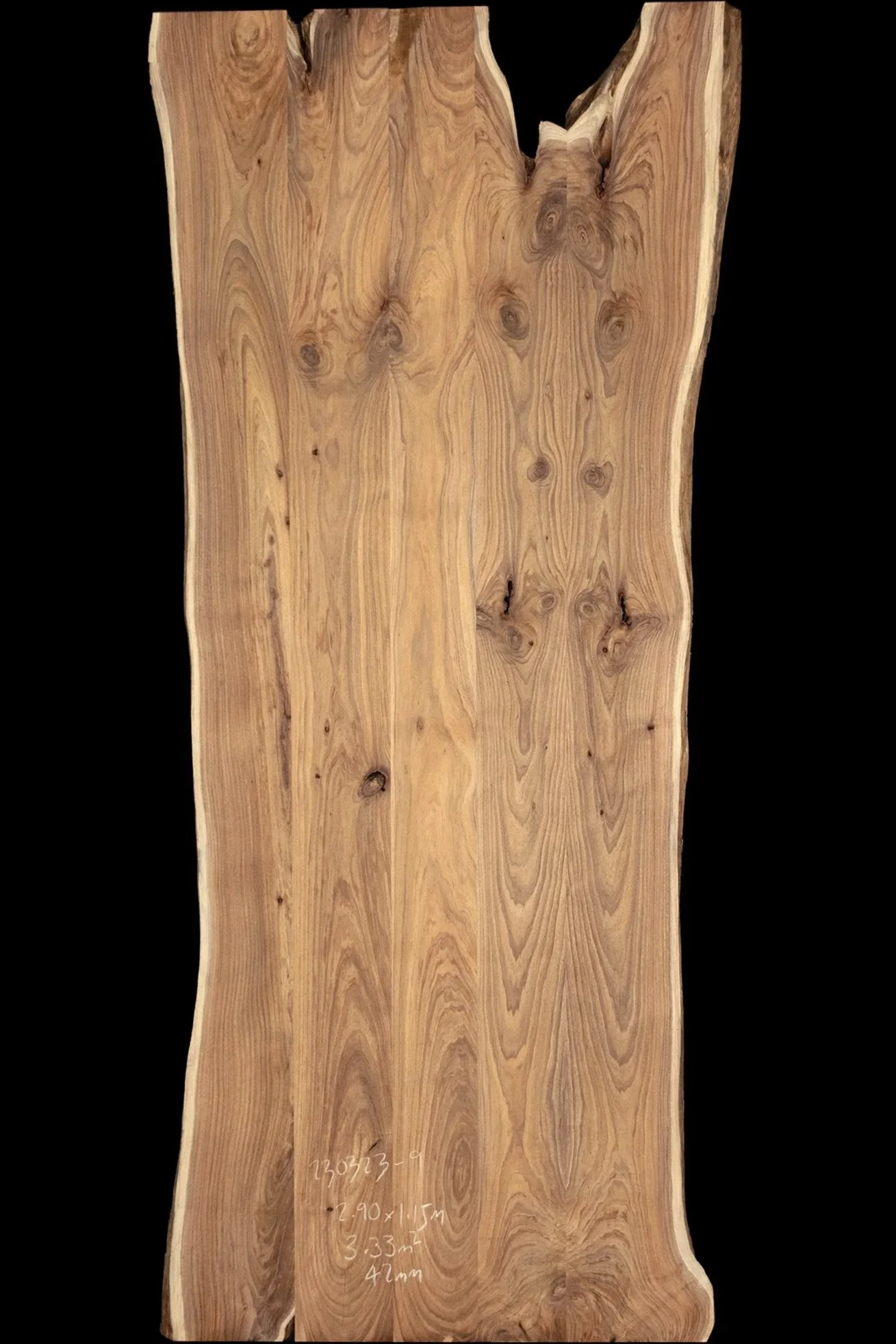 A large, natural blackeood slab with visible grain patterns and knots, placed against a black background.