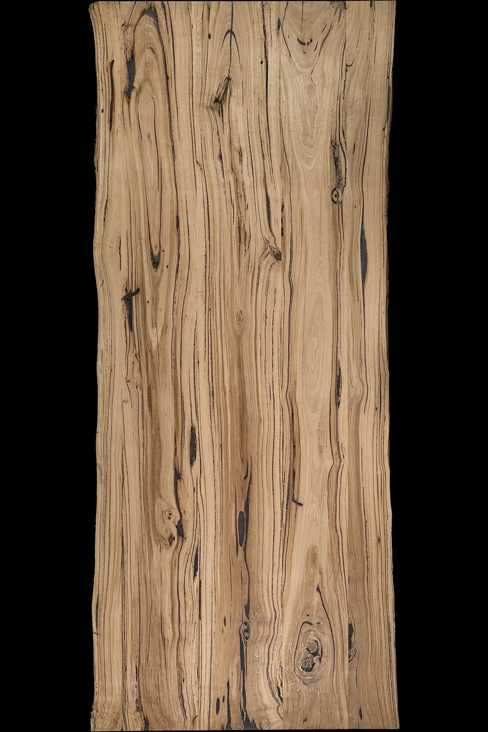 Close-up of a messmate hardwood slab with natural grain patterns and knots.