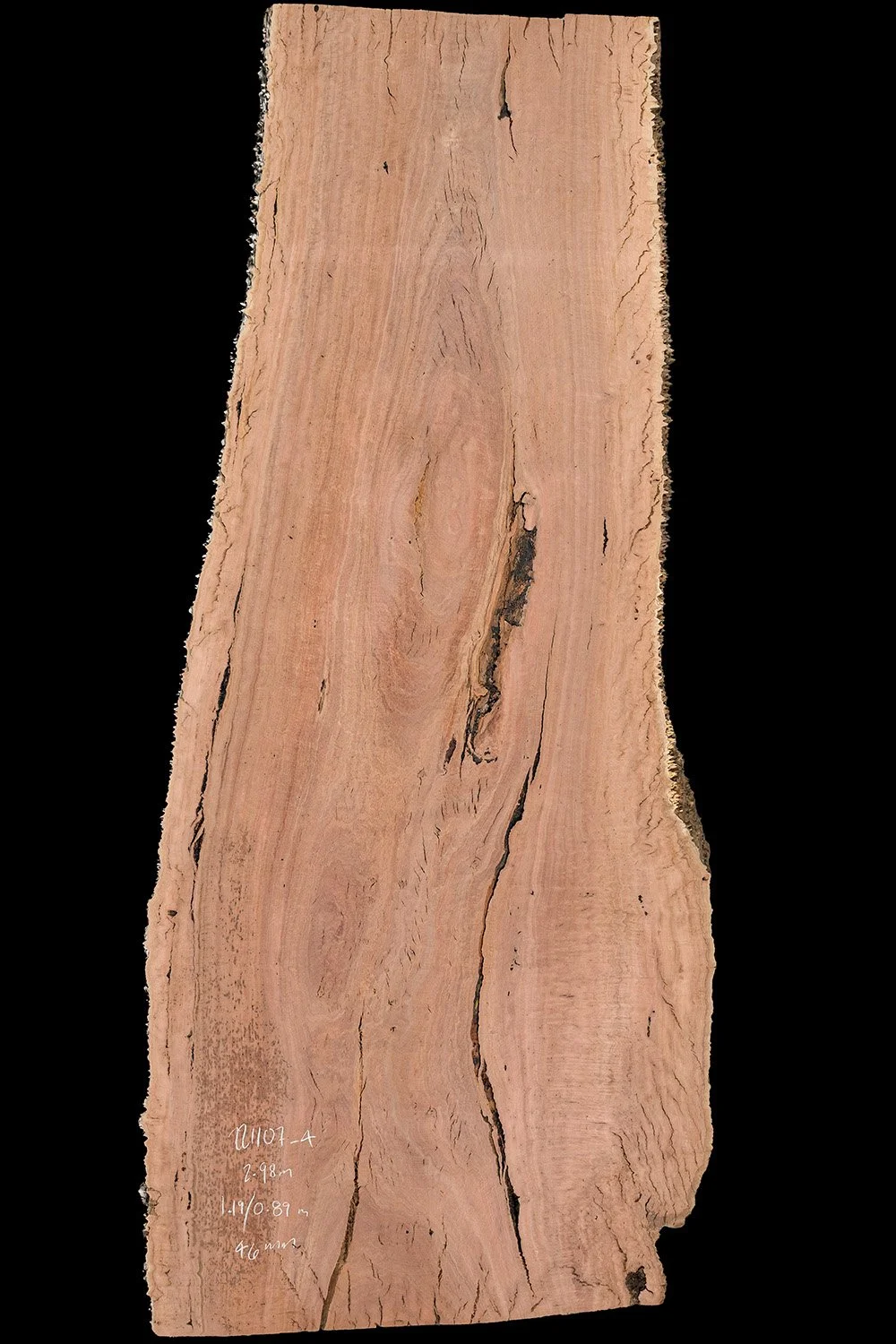 A close-up photograph of a natural wood slab with visible grain patterns and cracks, set against a black background.