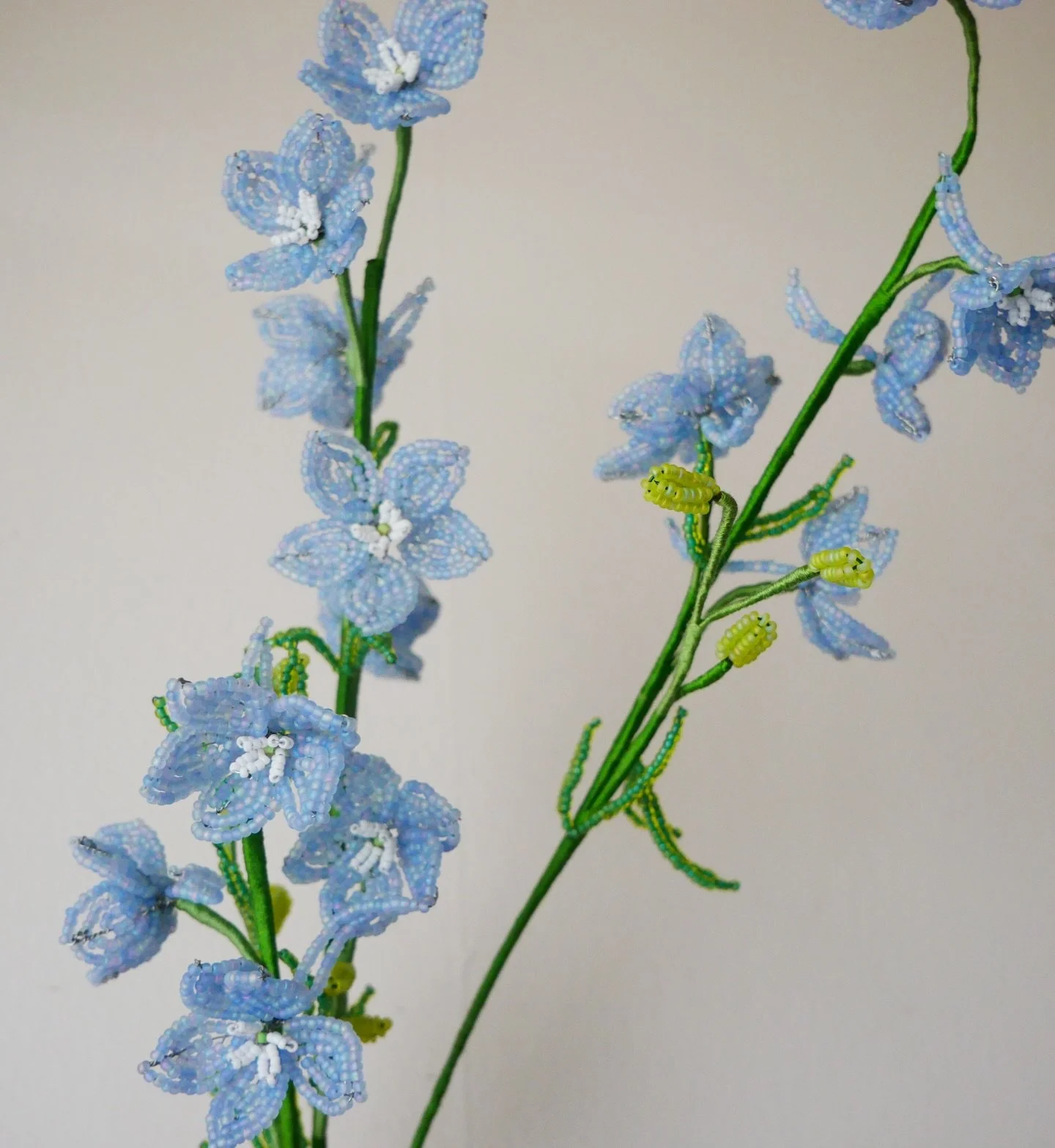 Delphinium. Each component is beaded by hand with Japanese glass beads and copper wire and bound together with cotton thread. I used very fine wire for the stems of these so they move and curve like real delphiniums. 

#botanicalart #beadwork #french