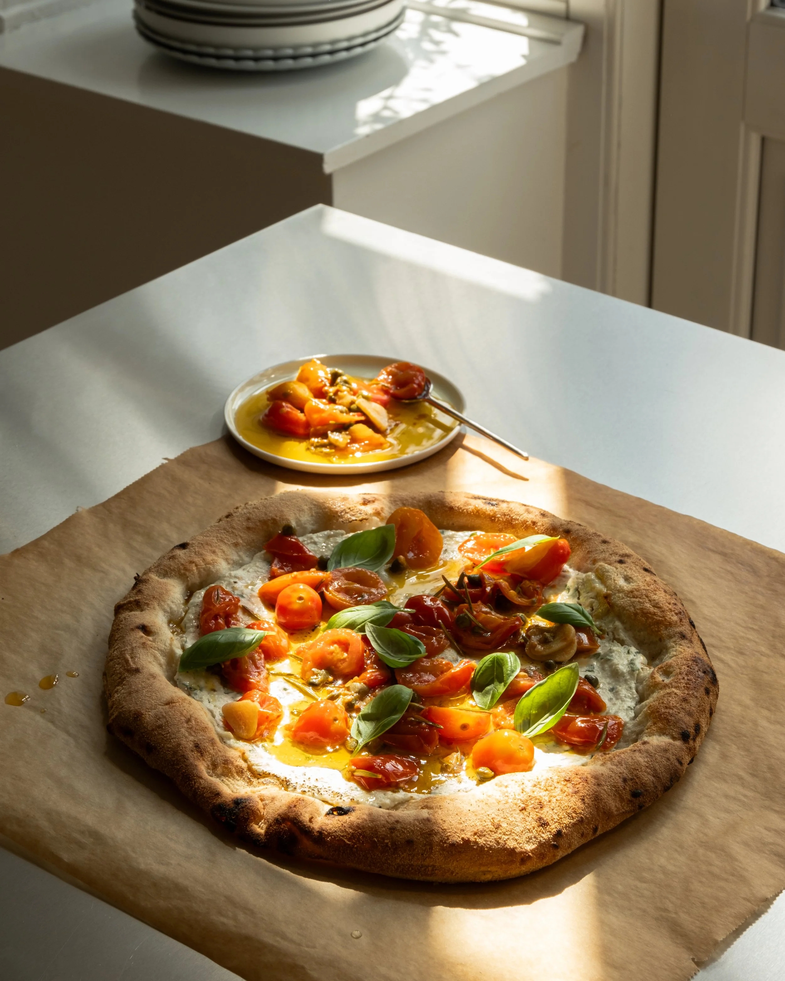 Surdejspizza bianca med ricottacreme, konfiterede tomater og basilikum