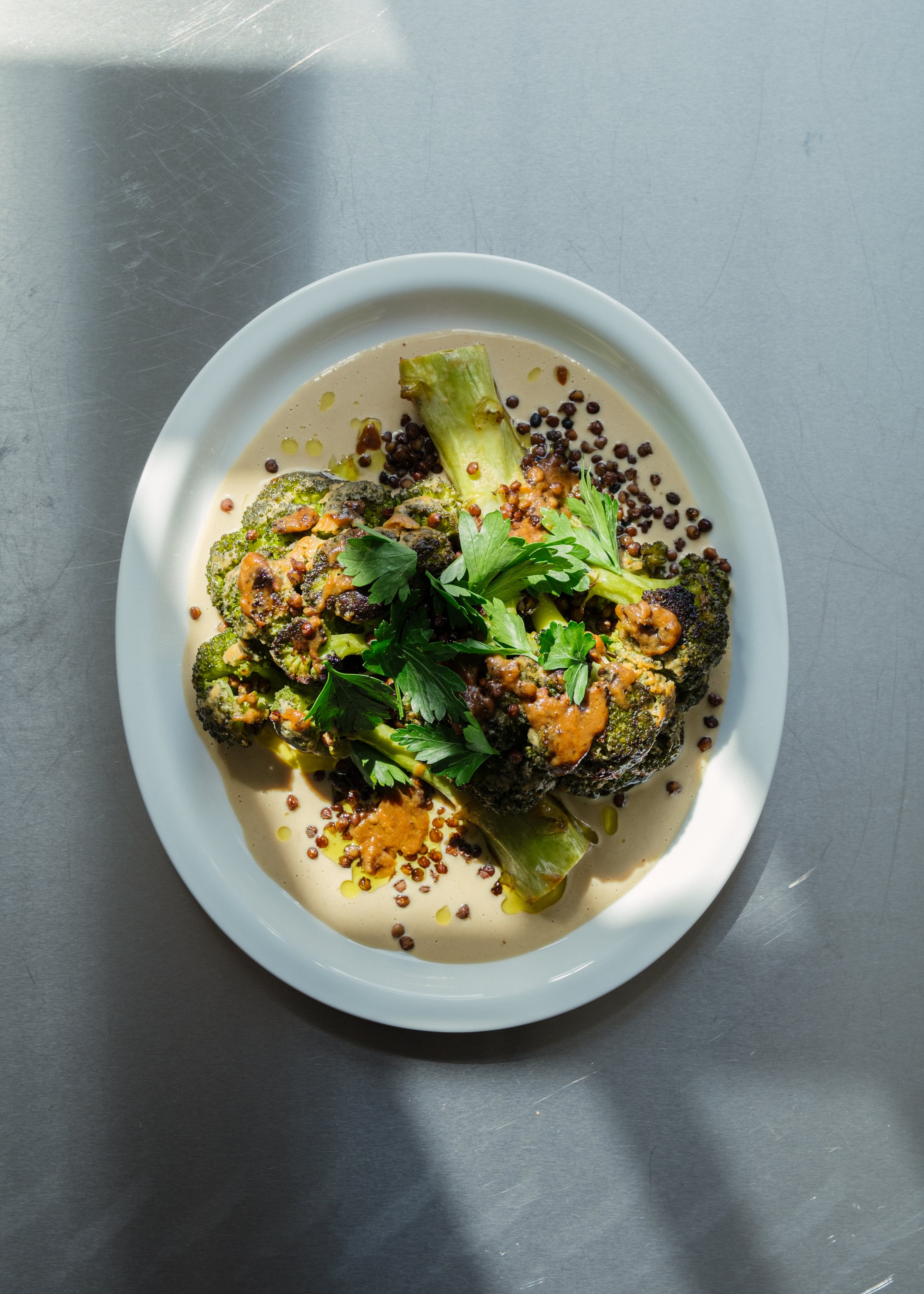 Stegt broccoli på en bund af tahinsauce toppet med sprøde linser