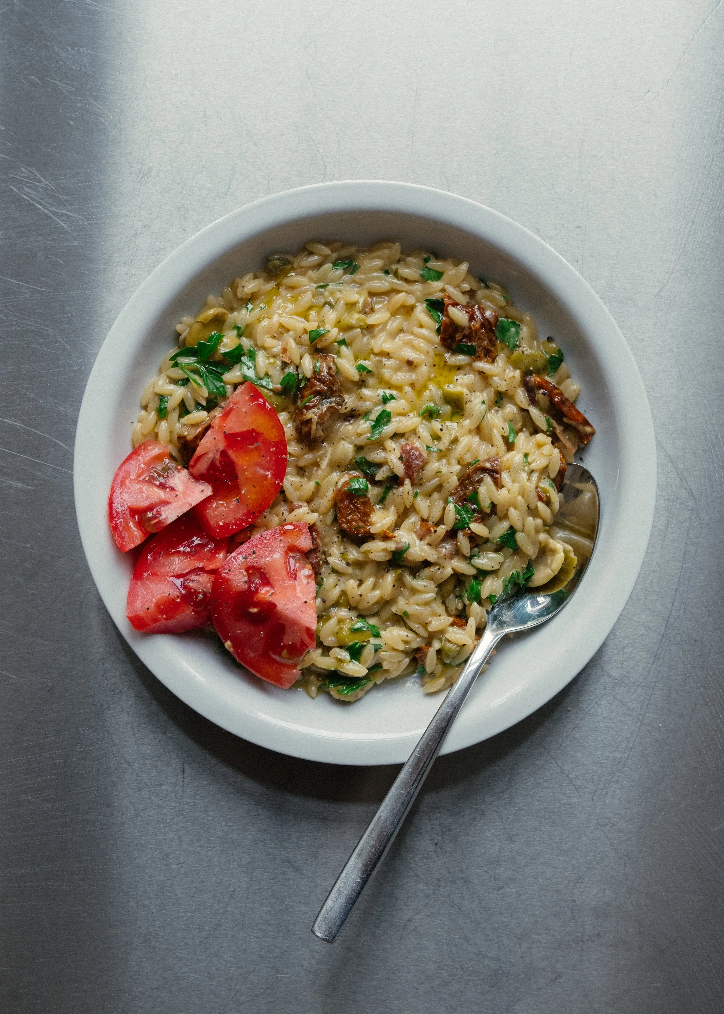 Cremet orzo med hvidløg, oliven, soltørrede tomater, fløde og friske tomater