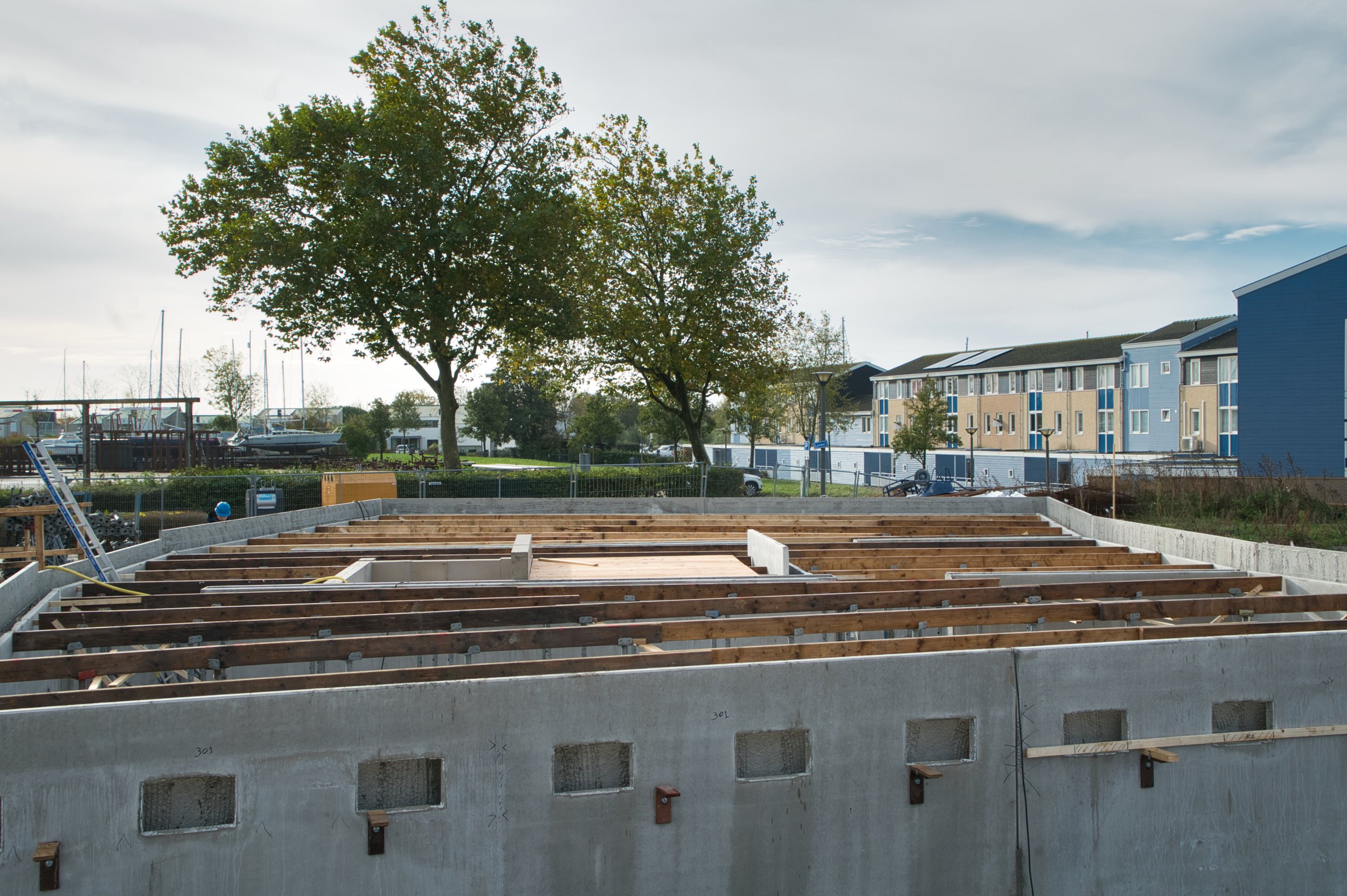 De wanden van de liftschacht en het trappenhuis in kelder zijn aangebracht. De tijdelijke ondersteuning van de begane grondvloer boven de kelder staat gereed.