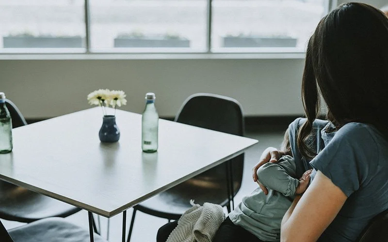 A mom nurses her toddler in the cafe above the Asheville art museum during a family photo session