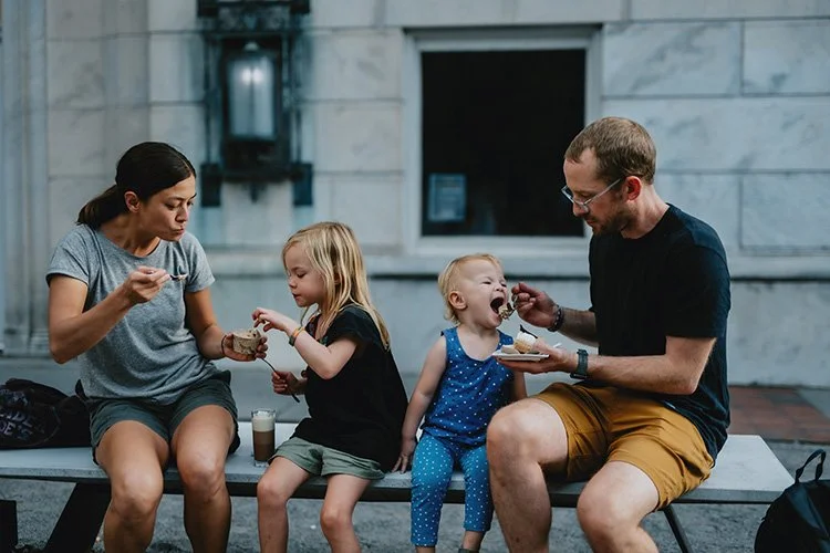 A family of four enjoys chocolate at the french broad chocolate lounge in downtown asheville during a family lifestyle photography session