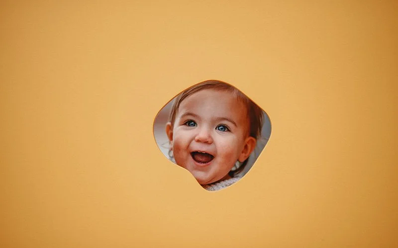 a baby with blue eyes smiles at the asheville art museum during a family photo shoot