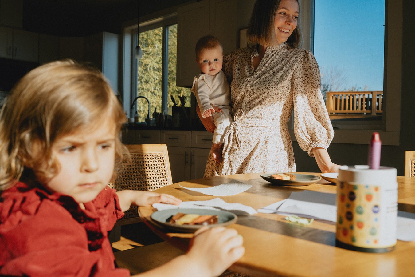 a family smiles inside of their well lit home during an unposed documentary family session in Asheville NC