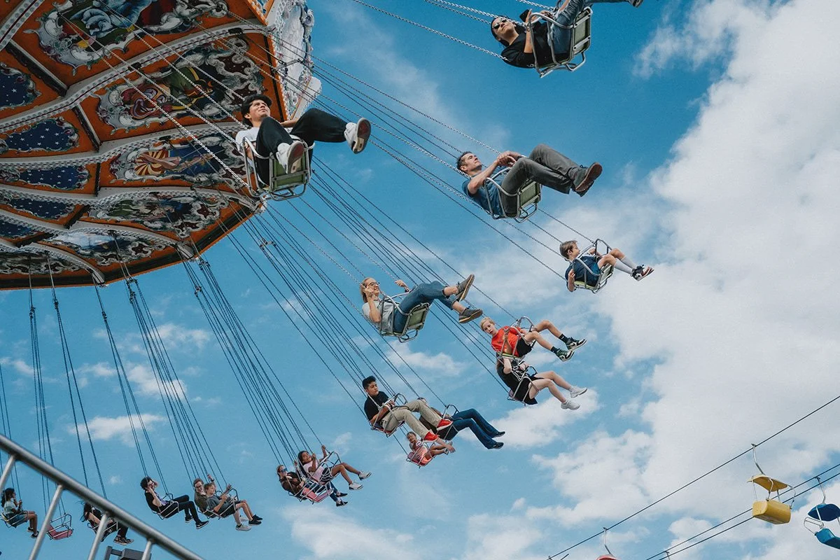 a family rides the swings at the mountain state fair in asheville north carolina during a family photo shoot