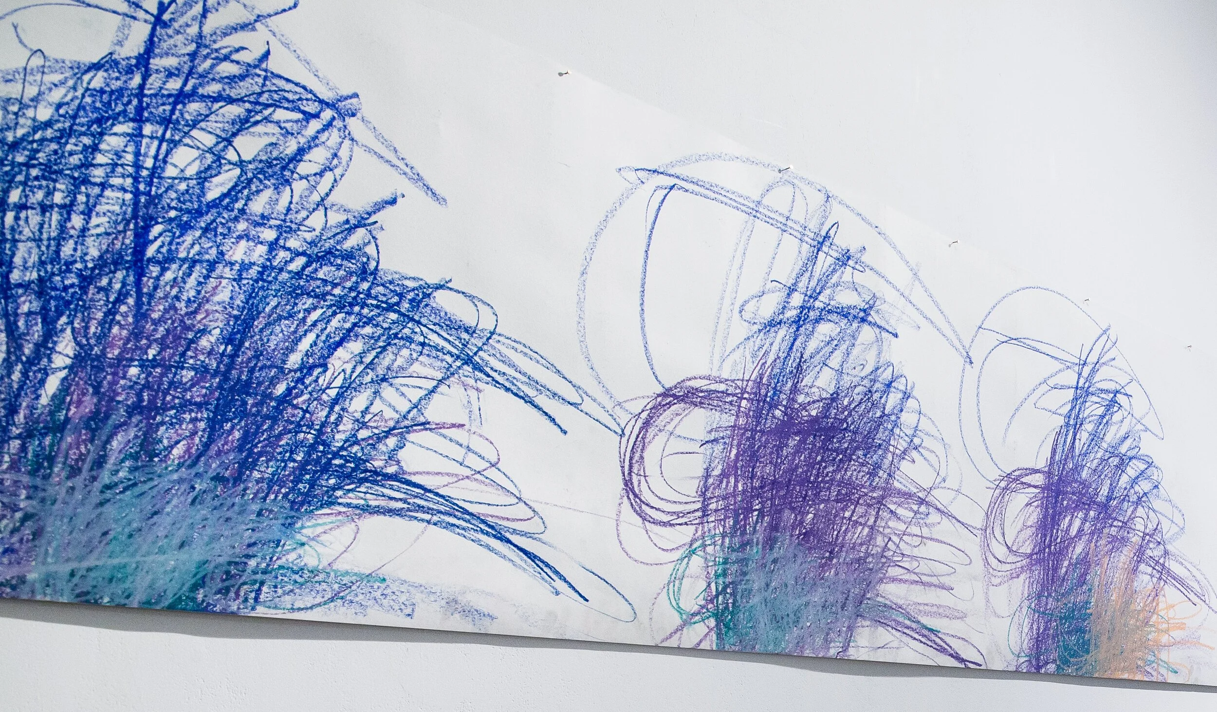 A large scroll of white paper with the words christmas and new york repeated and overlaid over each other in blue, purple and green. The text becomes illegible. 