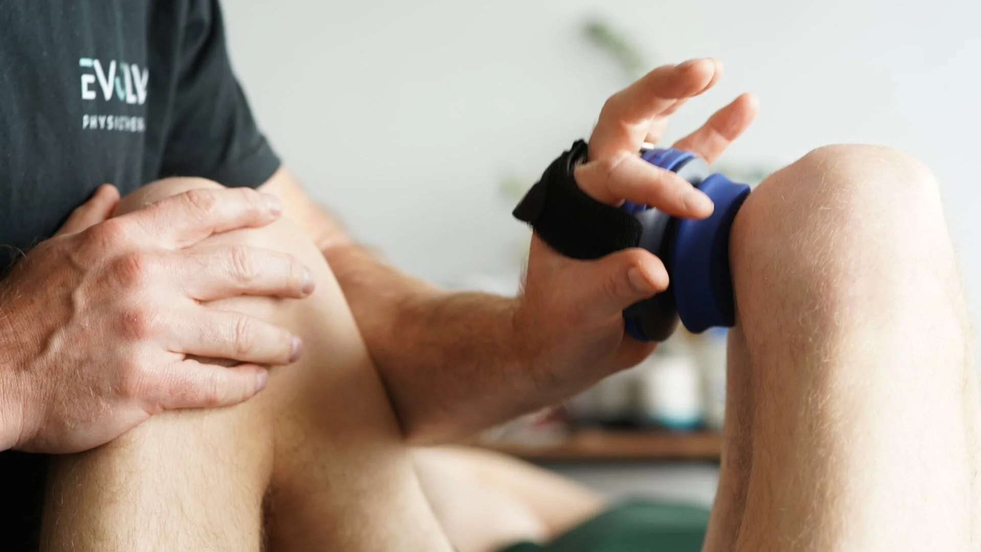 Physiotherapist measuring knee strength with a hand-held dynamometer at Evolve Physiotherapy, Swansea
