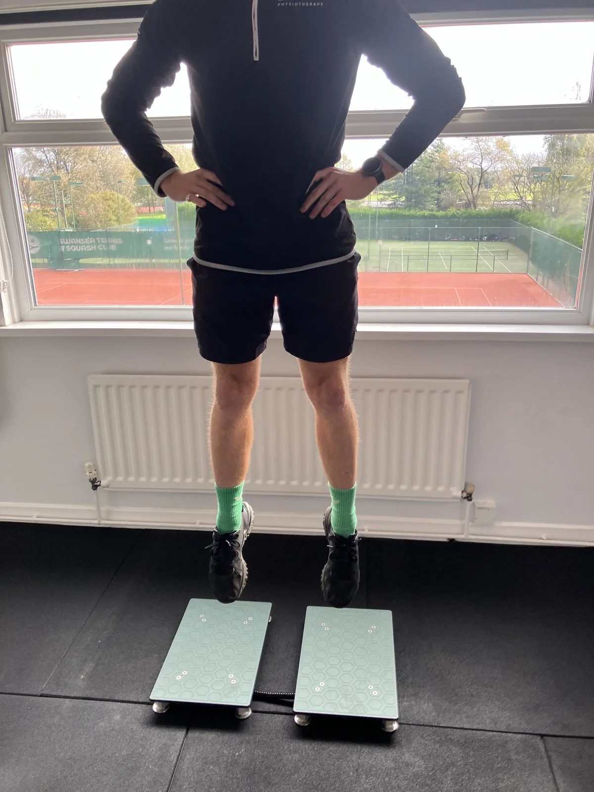 Athlete in the flight phase of a countermovement jump (CMJ) above VALD force plates at Evolve Physiotherapy, Swansea