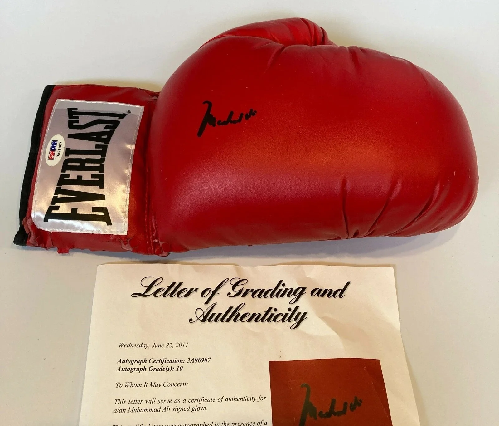 Authentic Muhammad Ali autograph verified by a trusted authentication company, showing fluid, looping signature style compared to fake versions on counterfeit memorabilia.