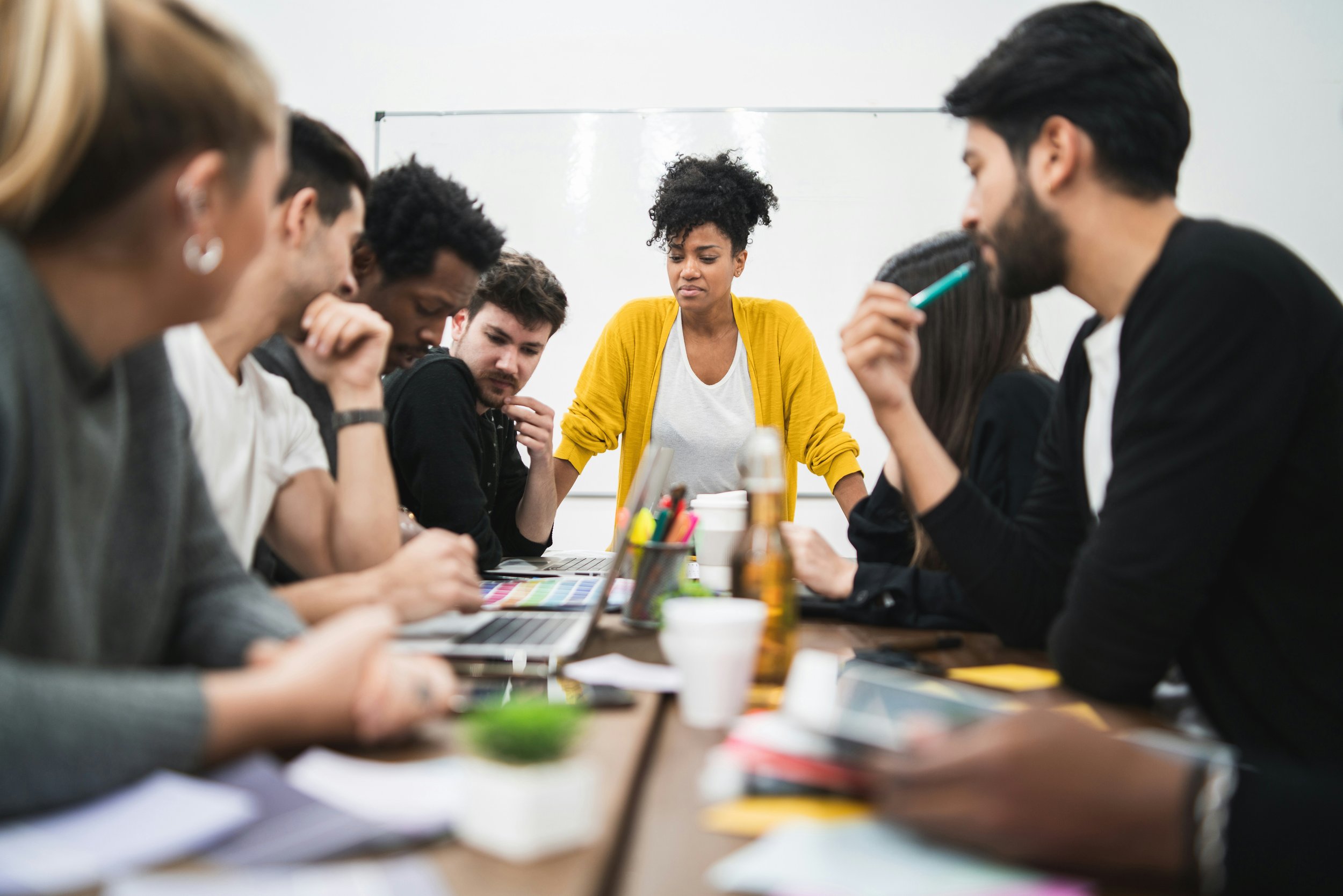 Coworkers gathered around a table thoughtfully collaborating
